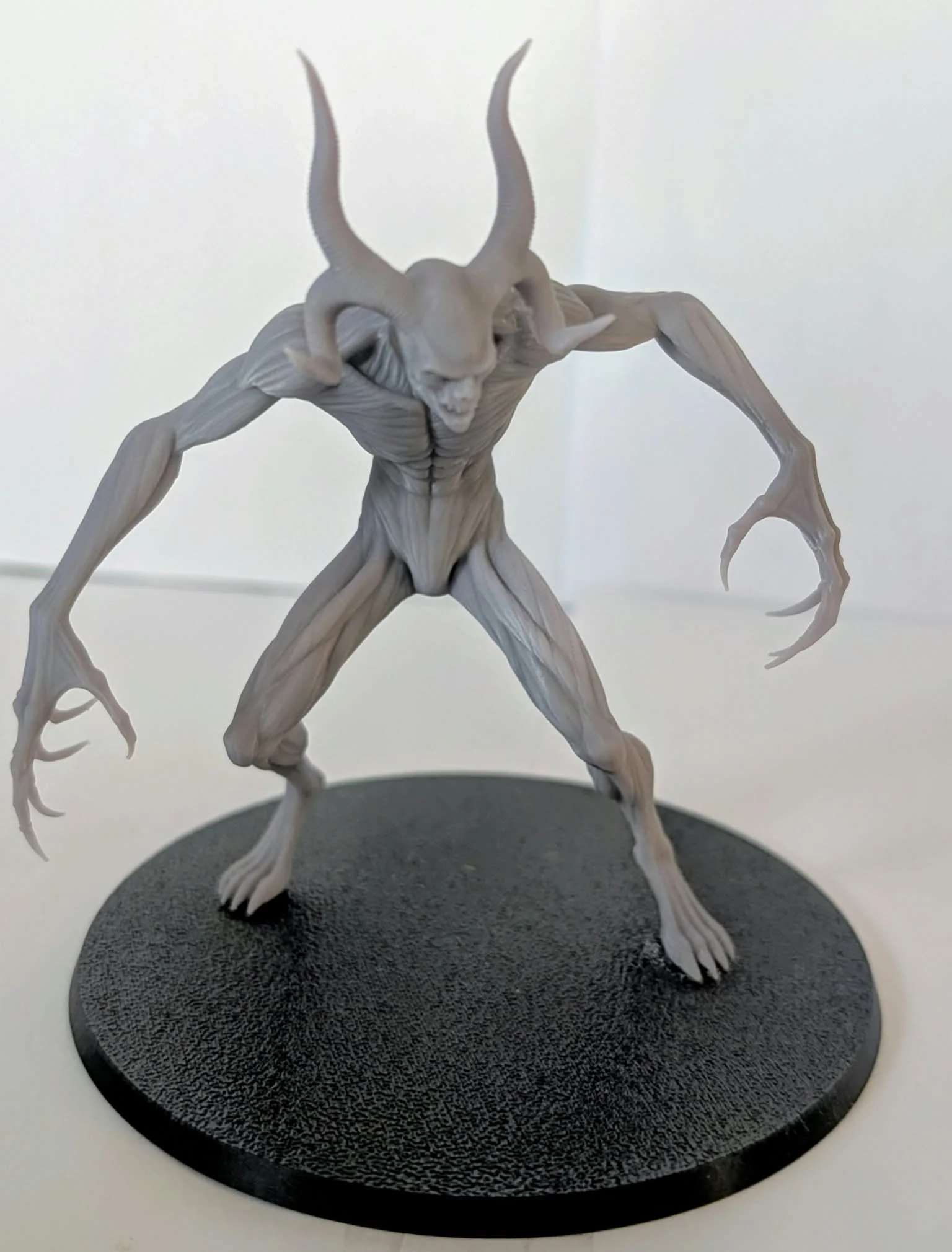 Demon – Horned Shadow resin miniature, unpainted, front view: long curved horns, clawed hands and a crouched stalking pose