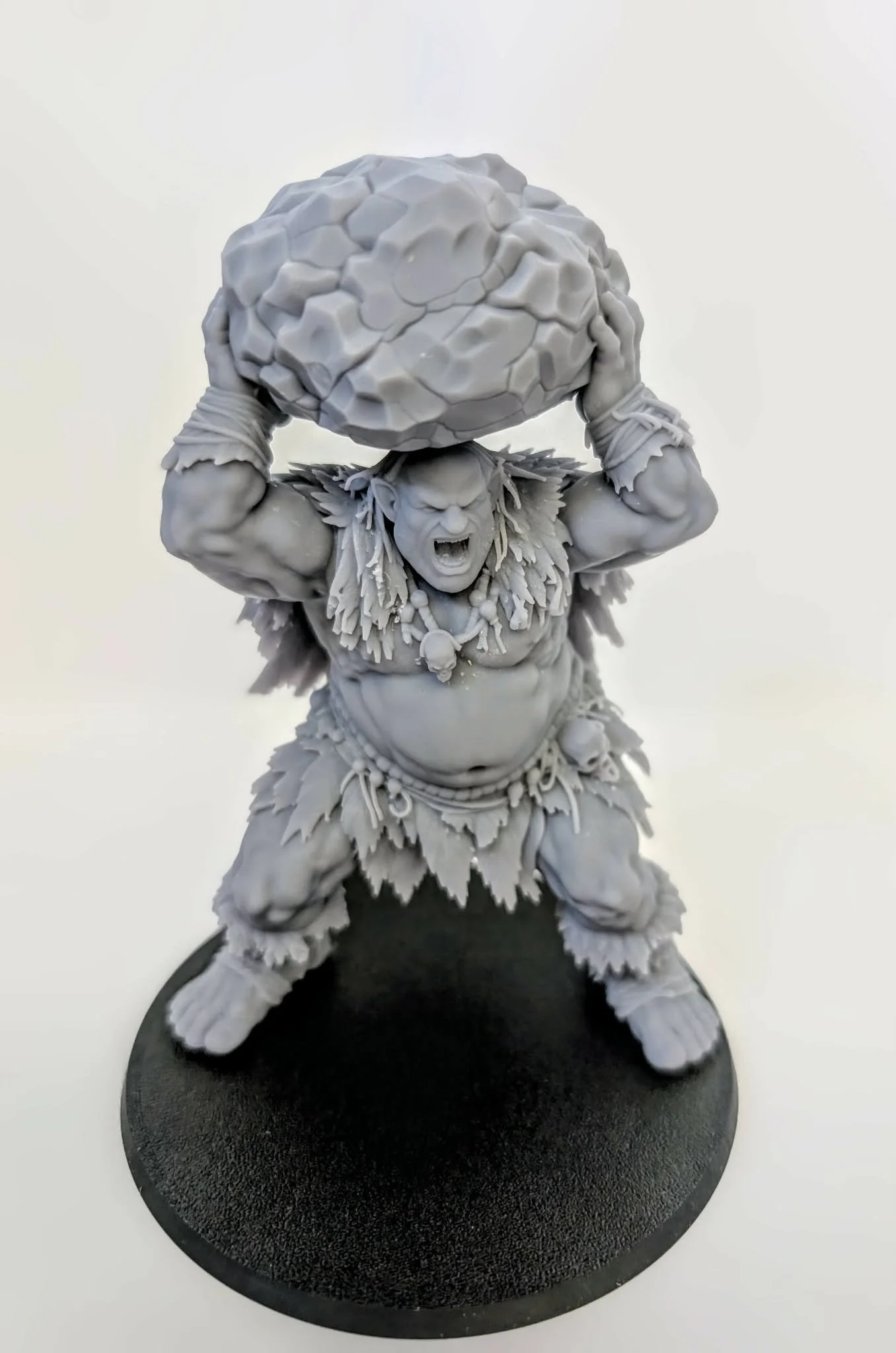 Hill Giant – Stonebreaker resin miniature, unpainted, front view with a boulder held above its head