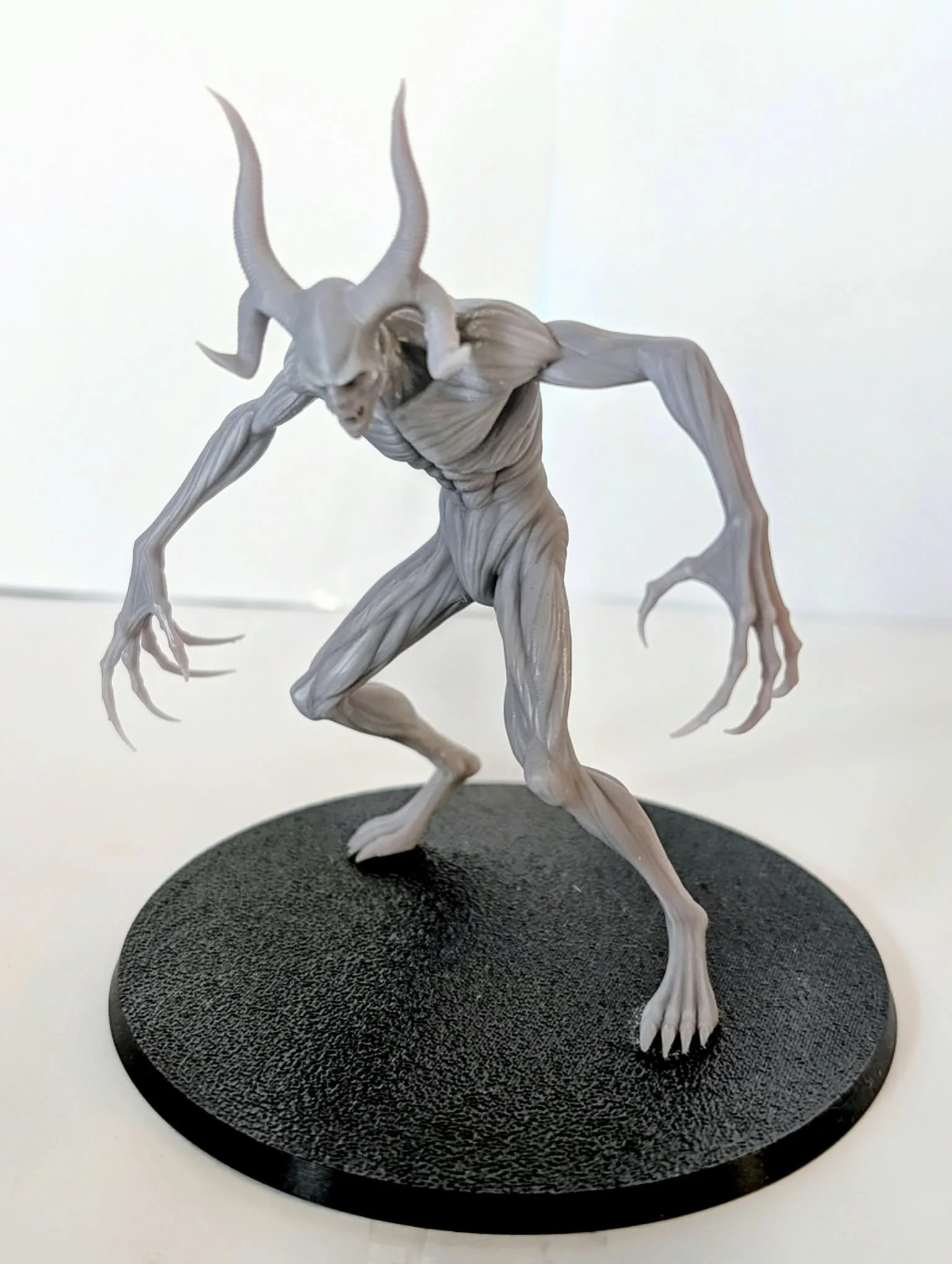 Demon – Horned Shadow resin miniature, unpainted, three-quarter view of its stalking pose on a round black base
