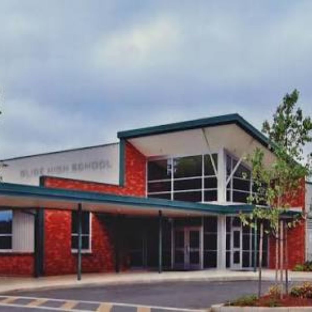 Exterior view of Glide High School building with brick walls, large windows, and modern architectural design.