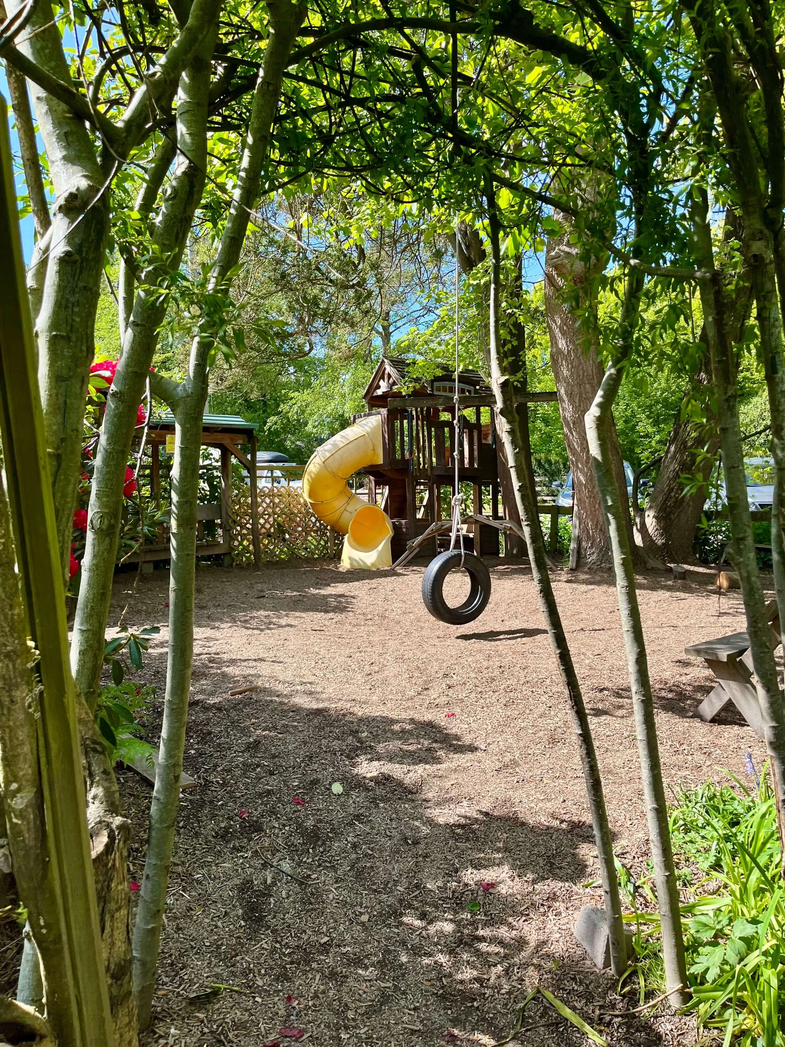 Slides and tyre swings seen through the trees at Southlands Heritage Farm.
