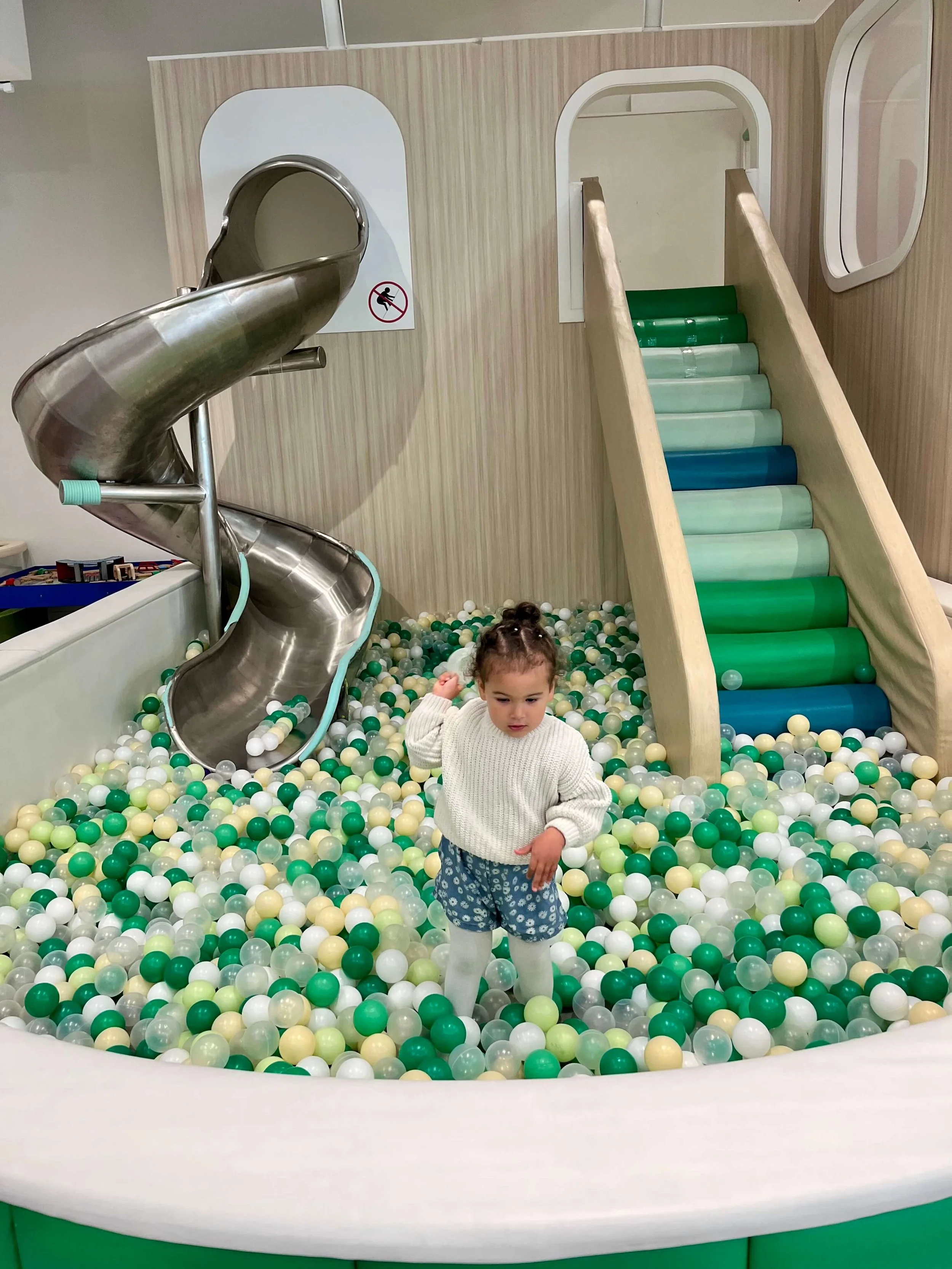 Little girl playing in a pool of soft balls at the Wonder Kids Cafe