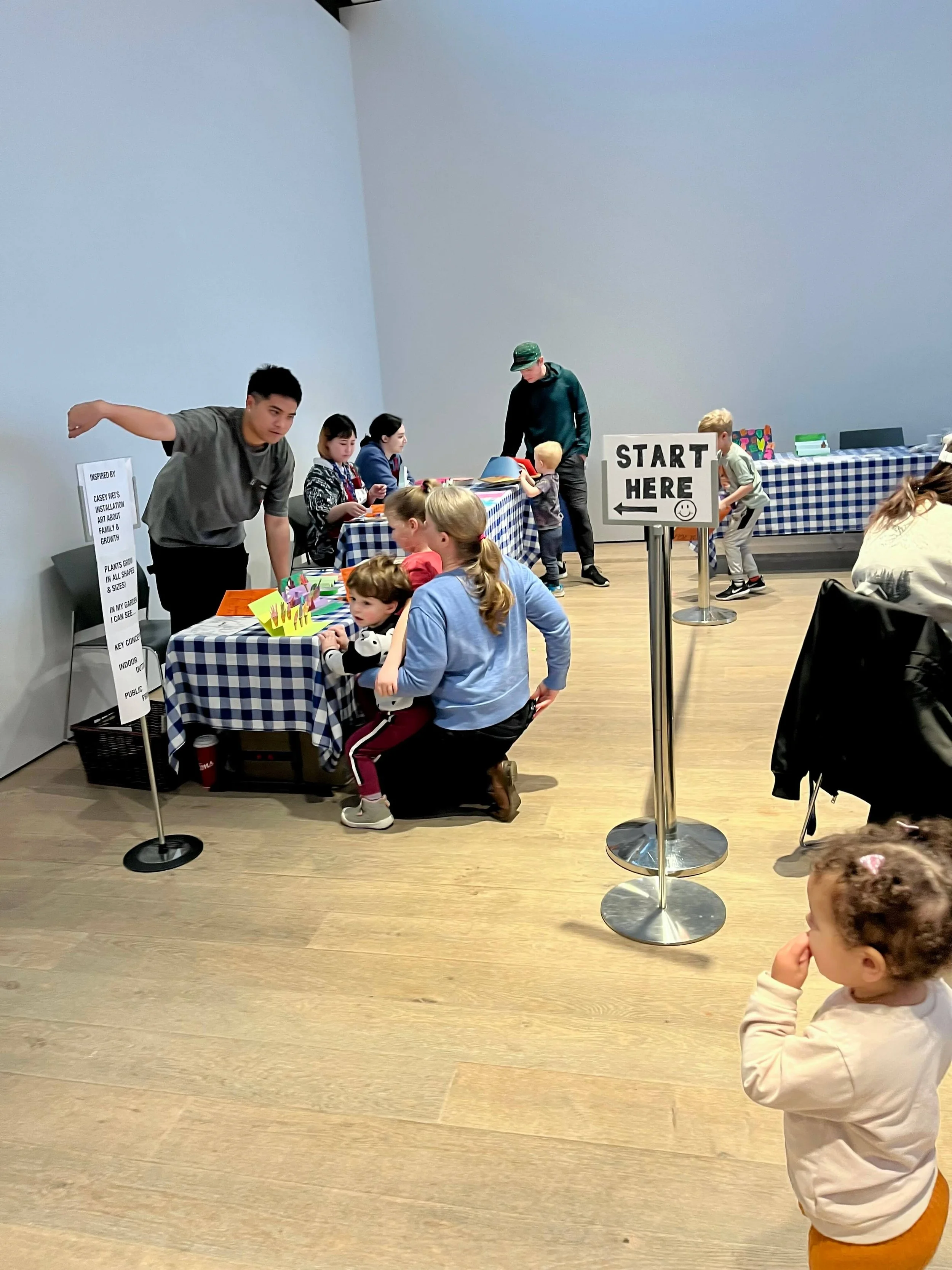 Little girl standing in line to get art supplies for a craft at the Polygon gallery