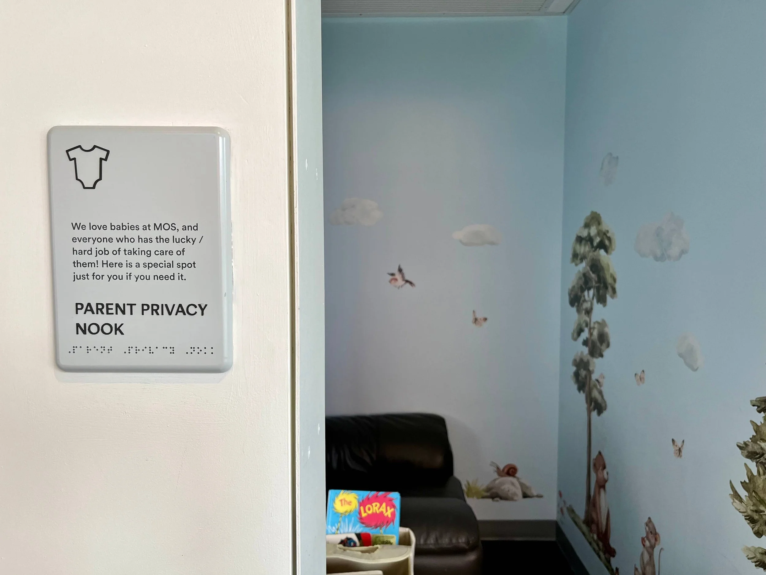 The entrance to a room called the parent priavcy nook. And a sign in front to the door explaining its for parents and their babies.