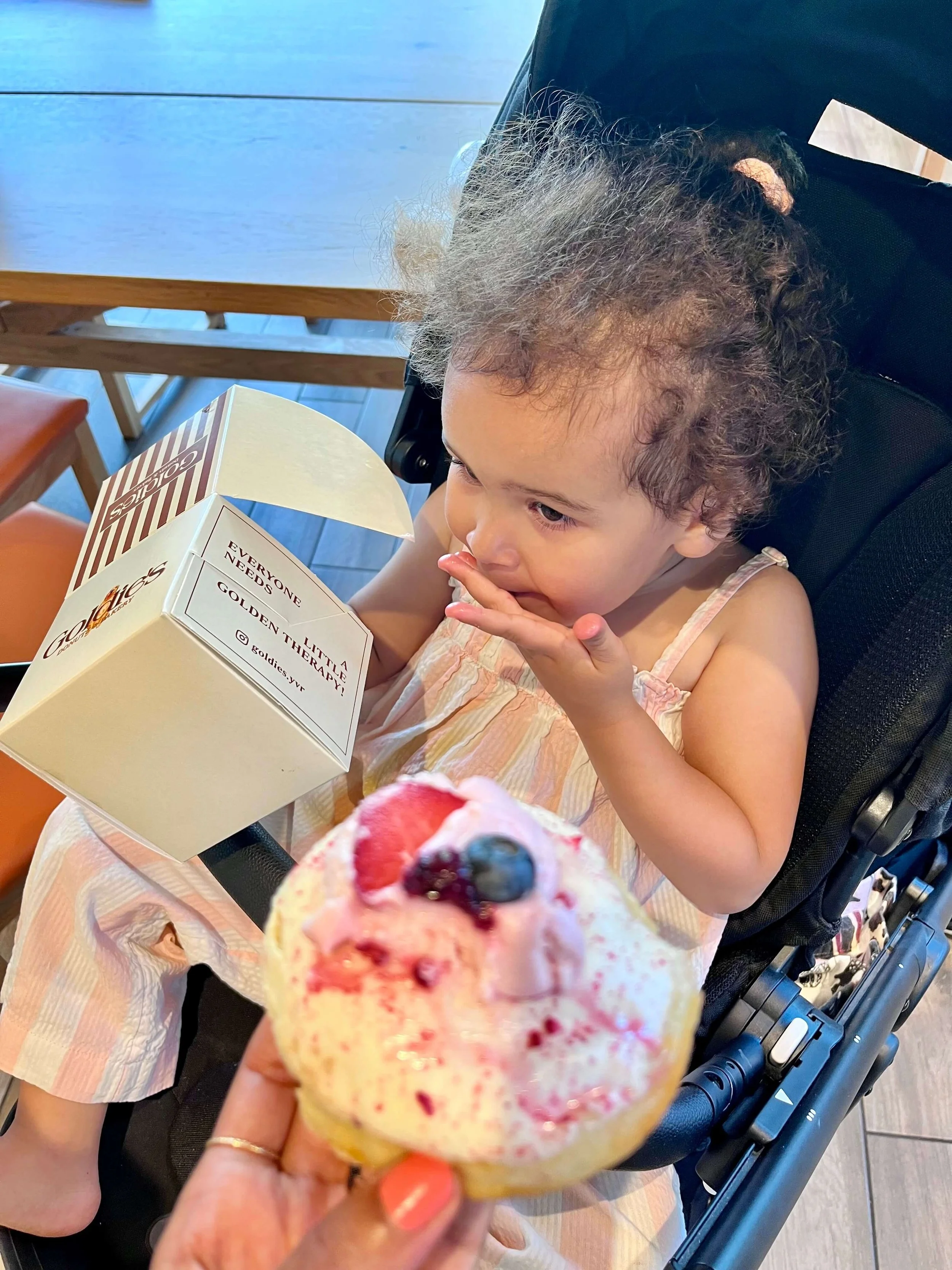 Little girl in a stroller eating a donut from Goldies in Horseshoe bay