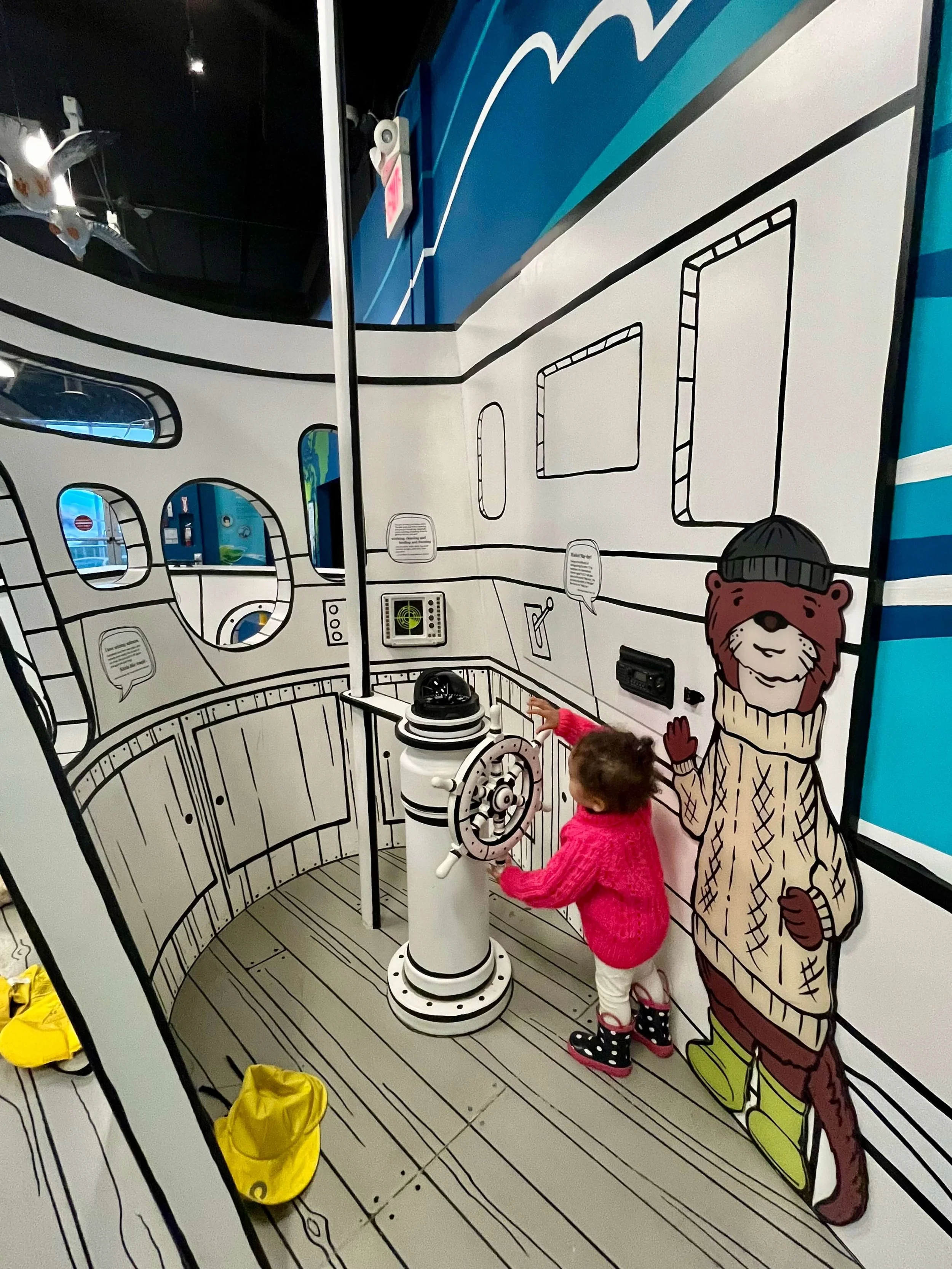 Little girl pretending to steer a ship at the Vancouver Maritime museum