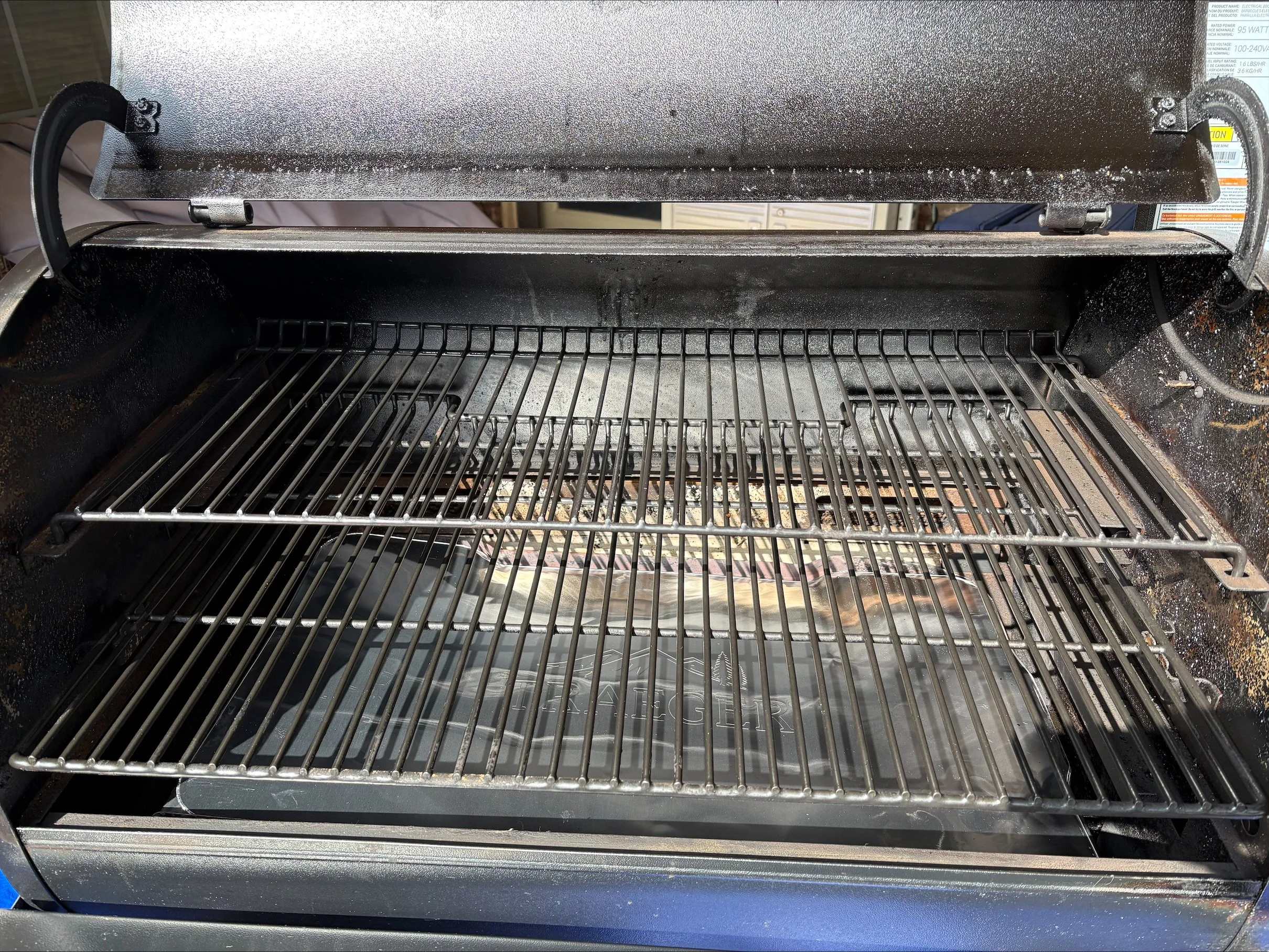 The inside of an empty black electric oven with a wire rack.