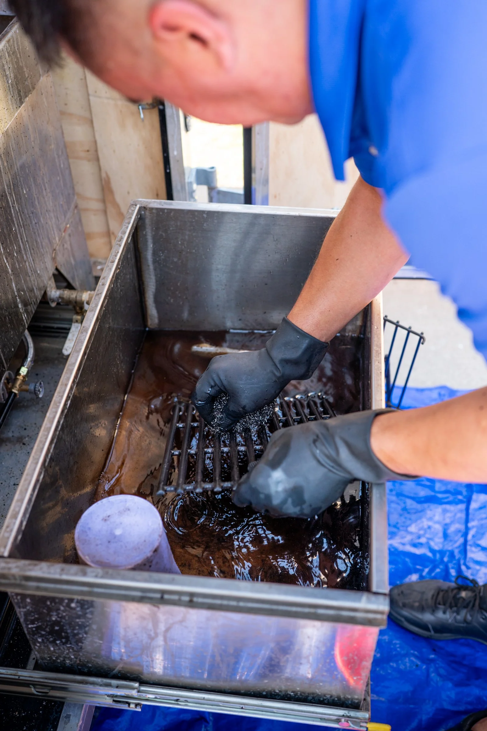 Grill cleaner dips grate into eco-friendly cleaning solution safe grill cleaning in Oklahoma City