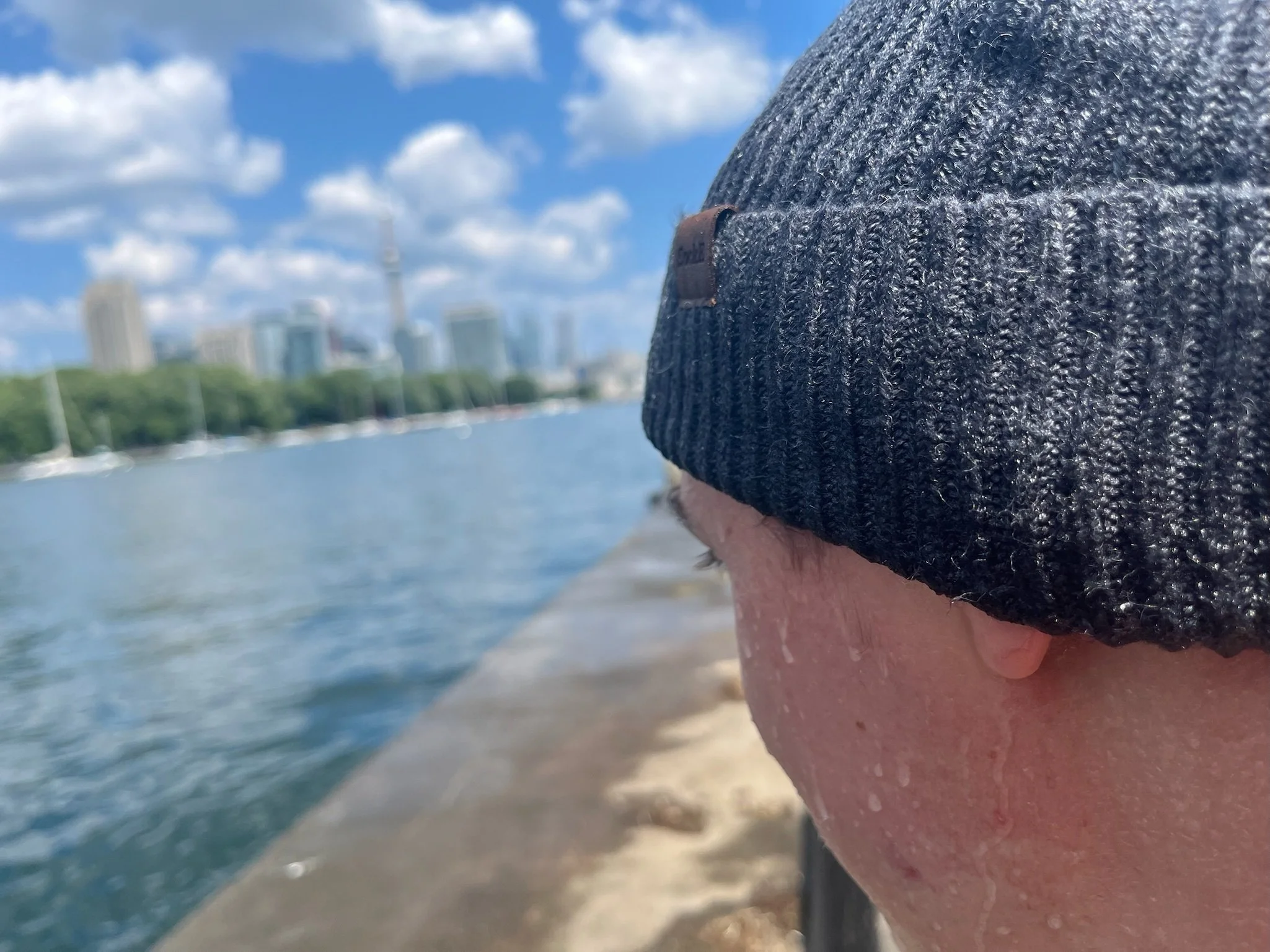 Close-up of a grey knit beanie worn beside the waterfront