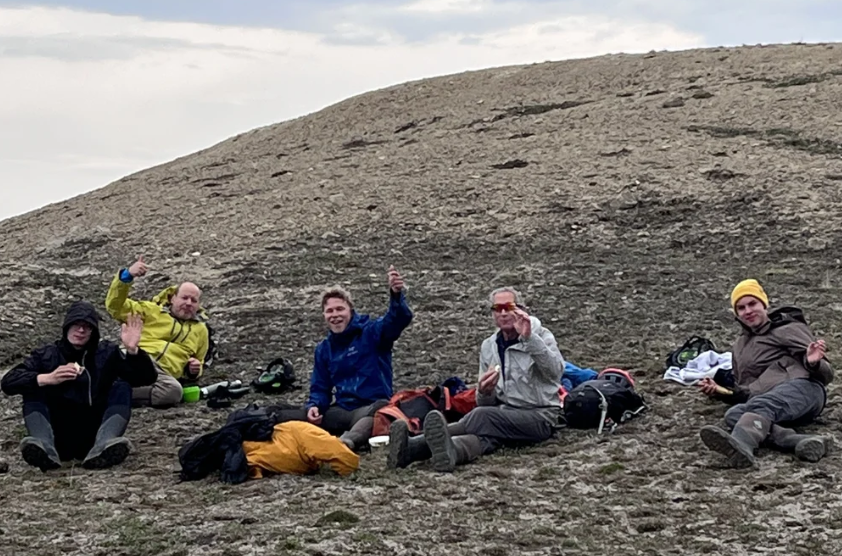 Group of hikers resting together on a rocky mountainside