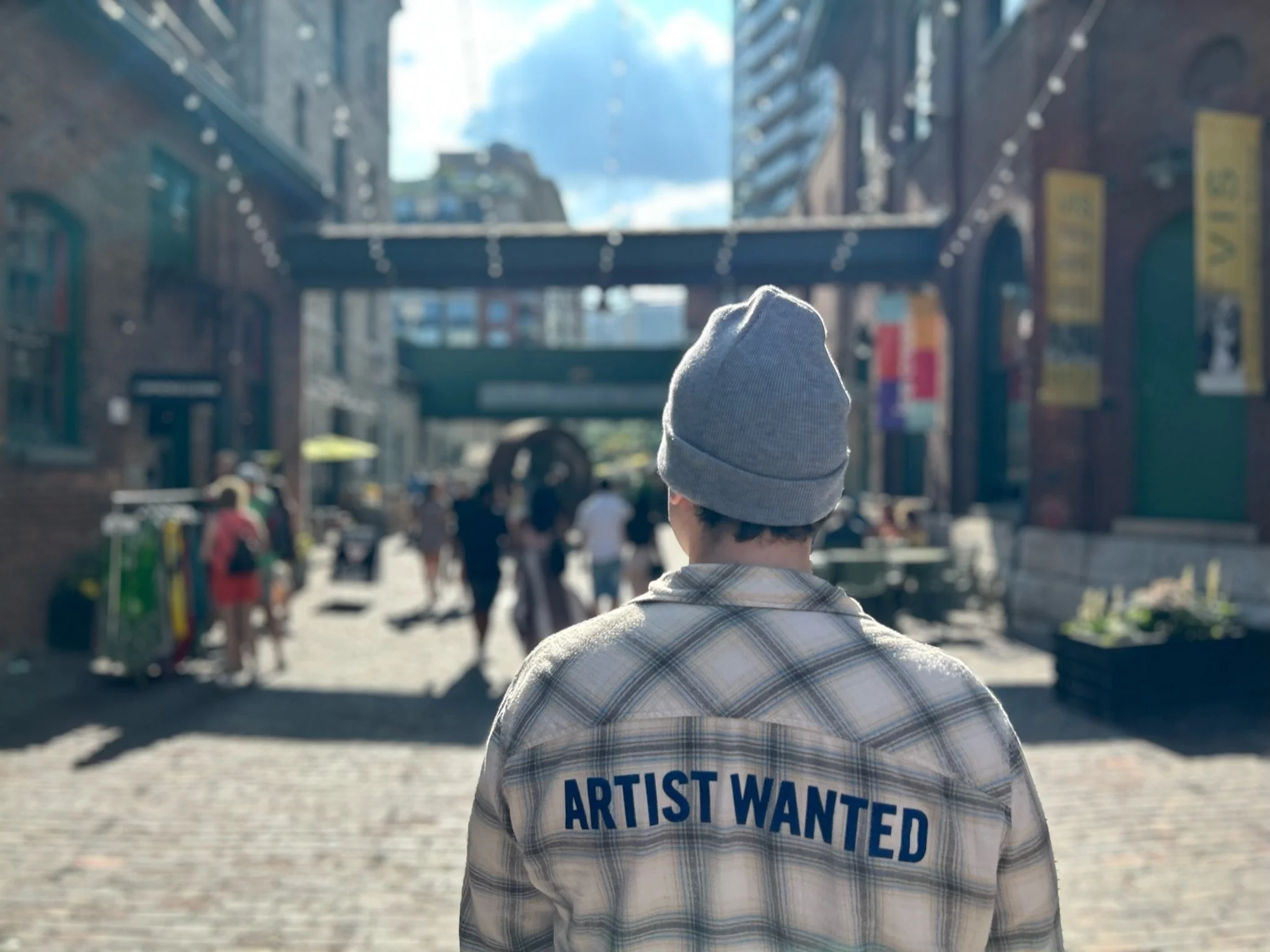 Person wearing a grey knit beanie walking through a city street