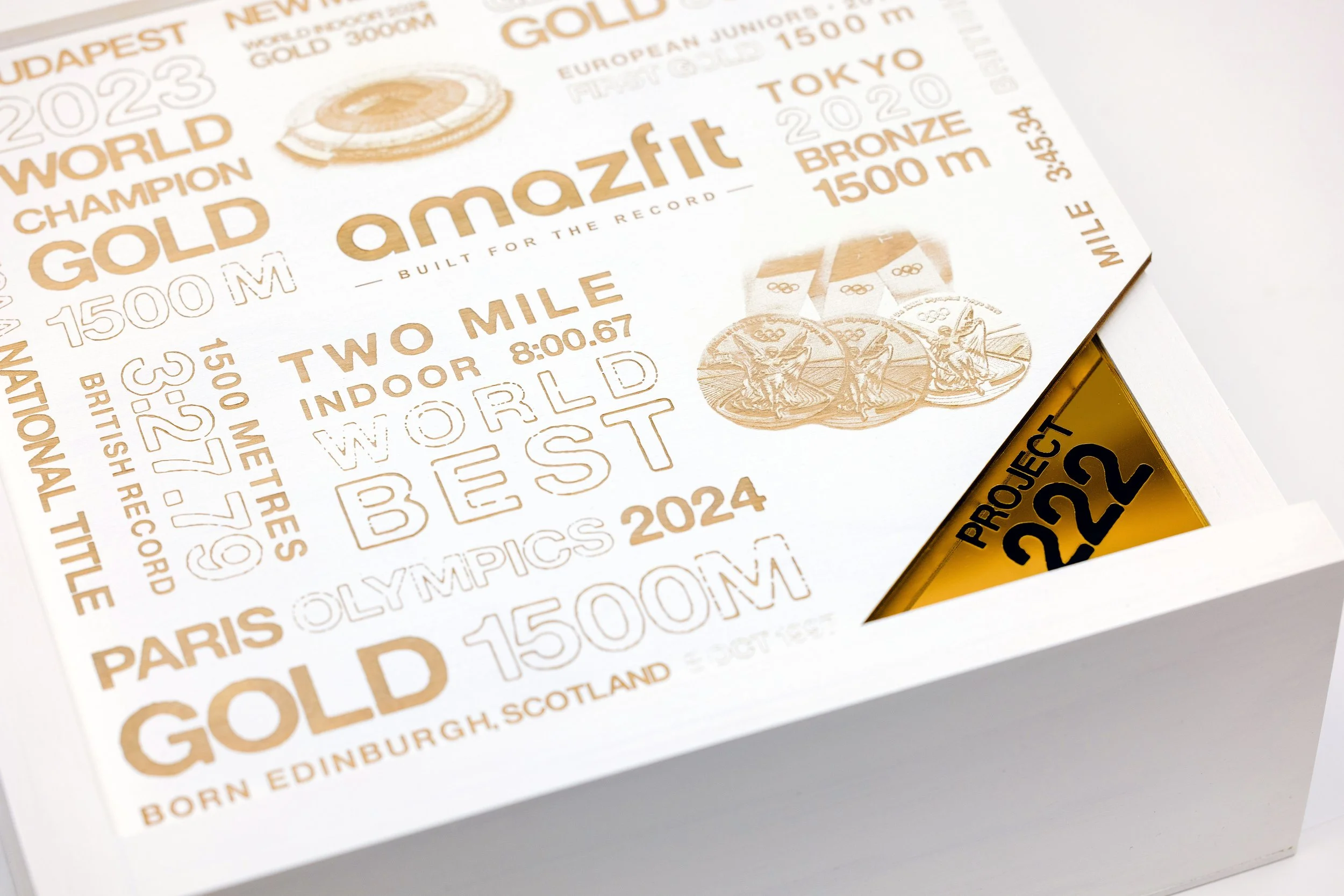 Josh Kerr Amazfit smartwatch seeding kit, satin white and gold acrylic box with Tokyo 2020 Olympics marathon graphics, custom fabrication by MC Laser Labs.