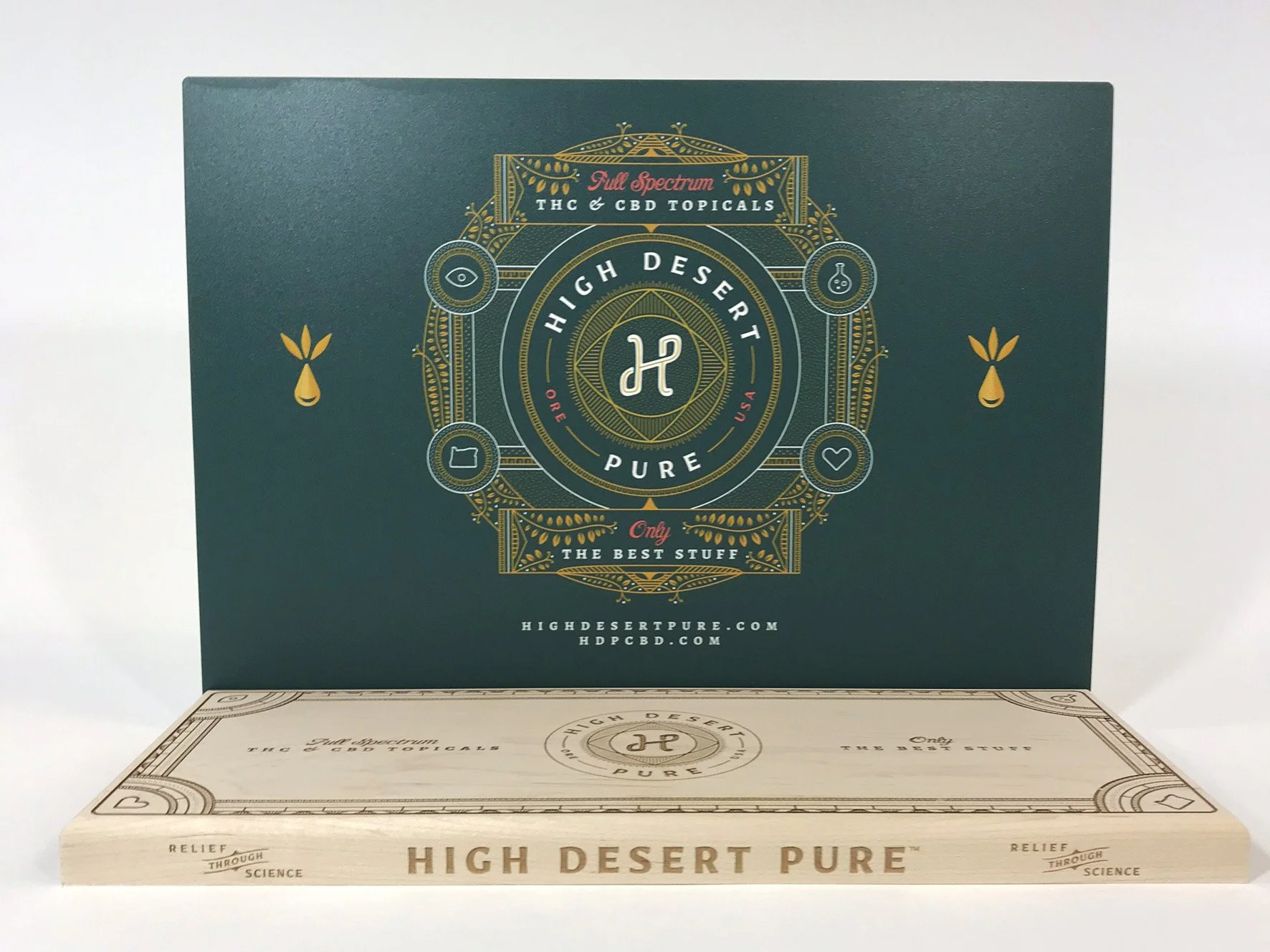 Green seeding kit box with gold, pink, and white text and graphics promoting High Desert Pure THC and CBD topical products, custom fabrication by MC Laser Labs.
