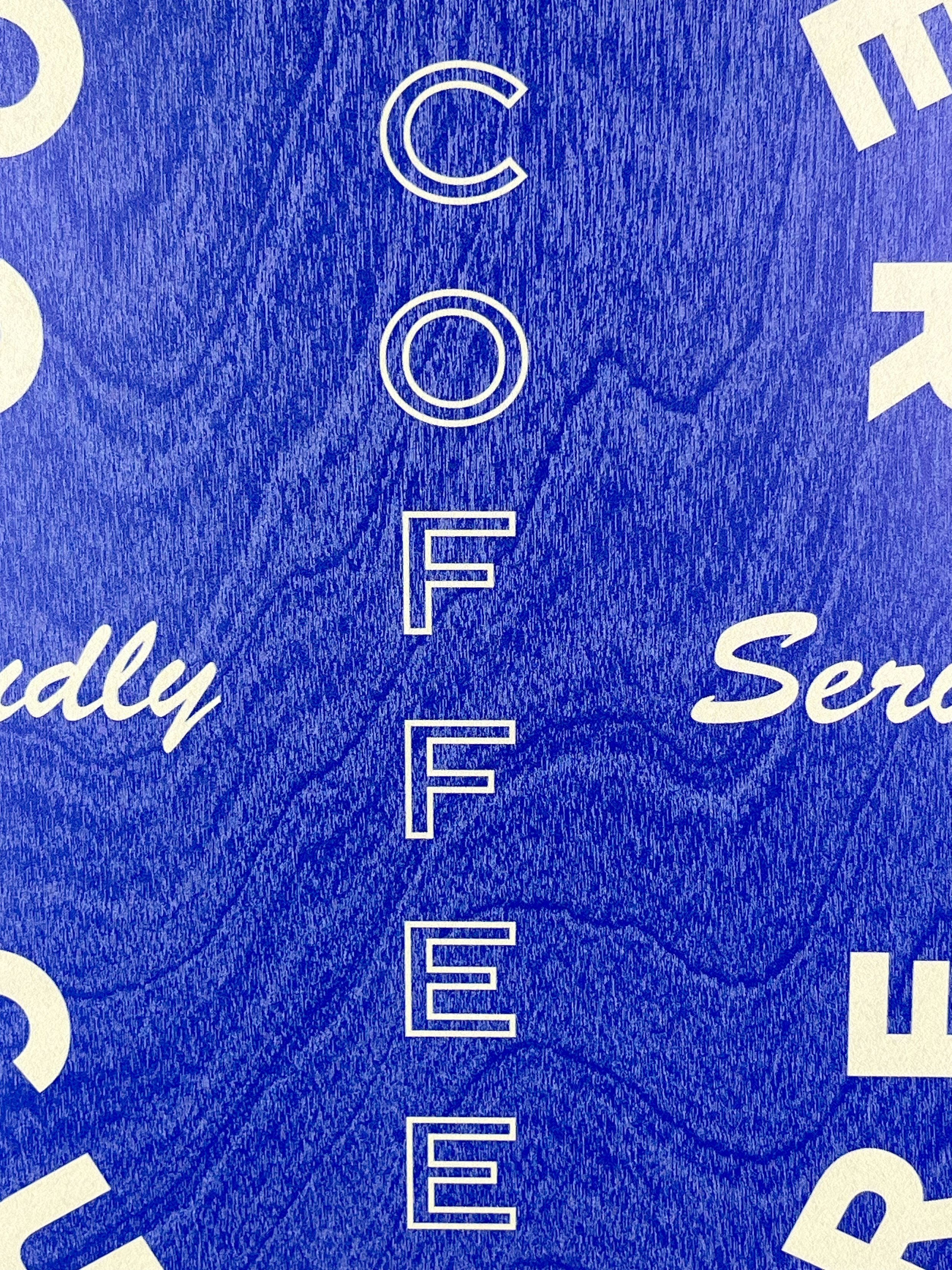 Close-up of a blue printed surface with white lettering, custom printing by MC Laser Labs.