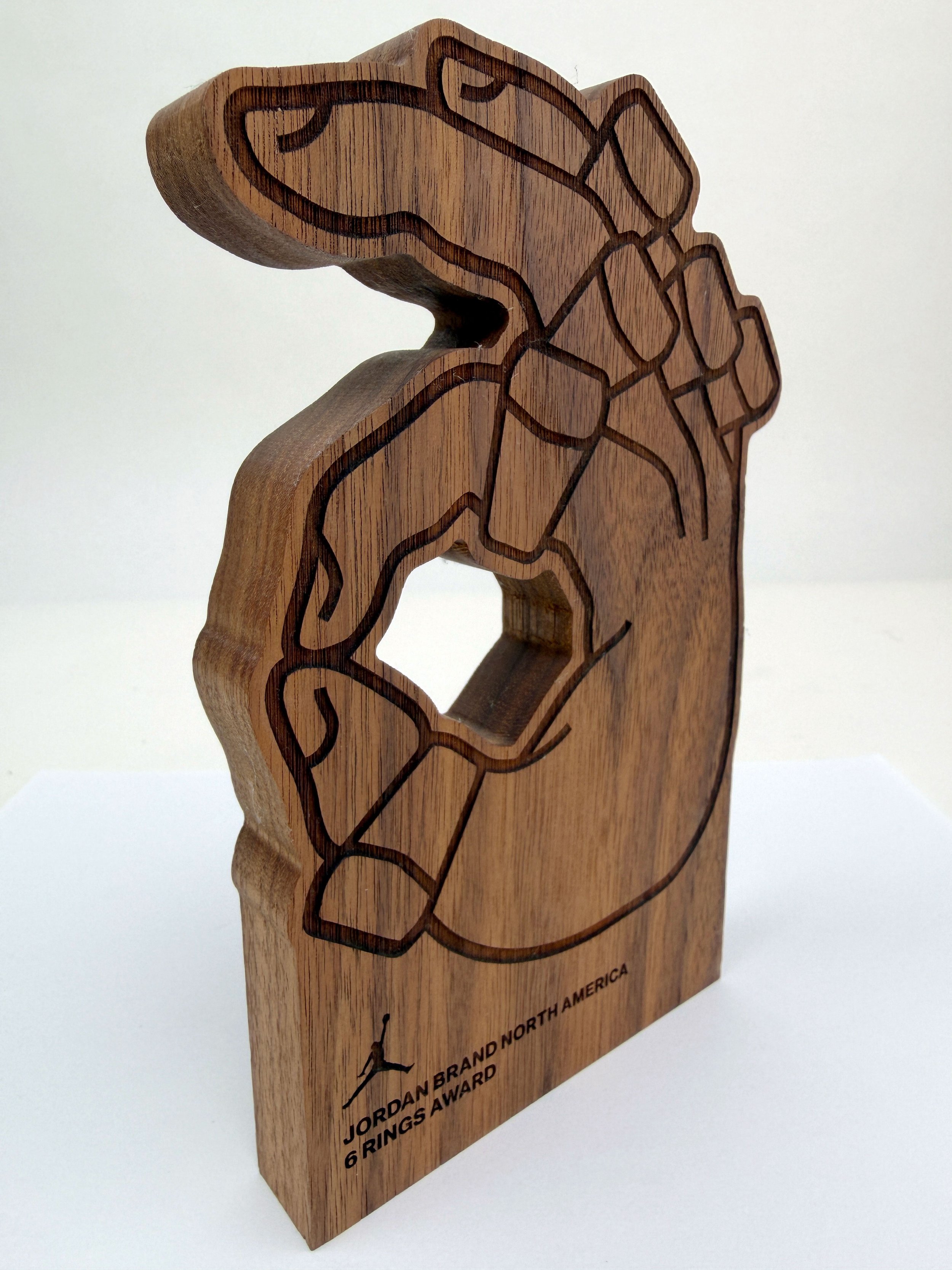 CO2 laser cut and engraved walnut Jordan Brand North America 6 Rings Award, featuring an outline of a basketball player dunking, custom laser cutting and engraving by MC Laser Labs.