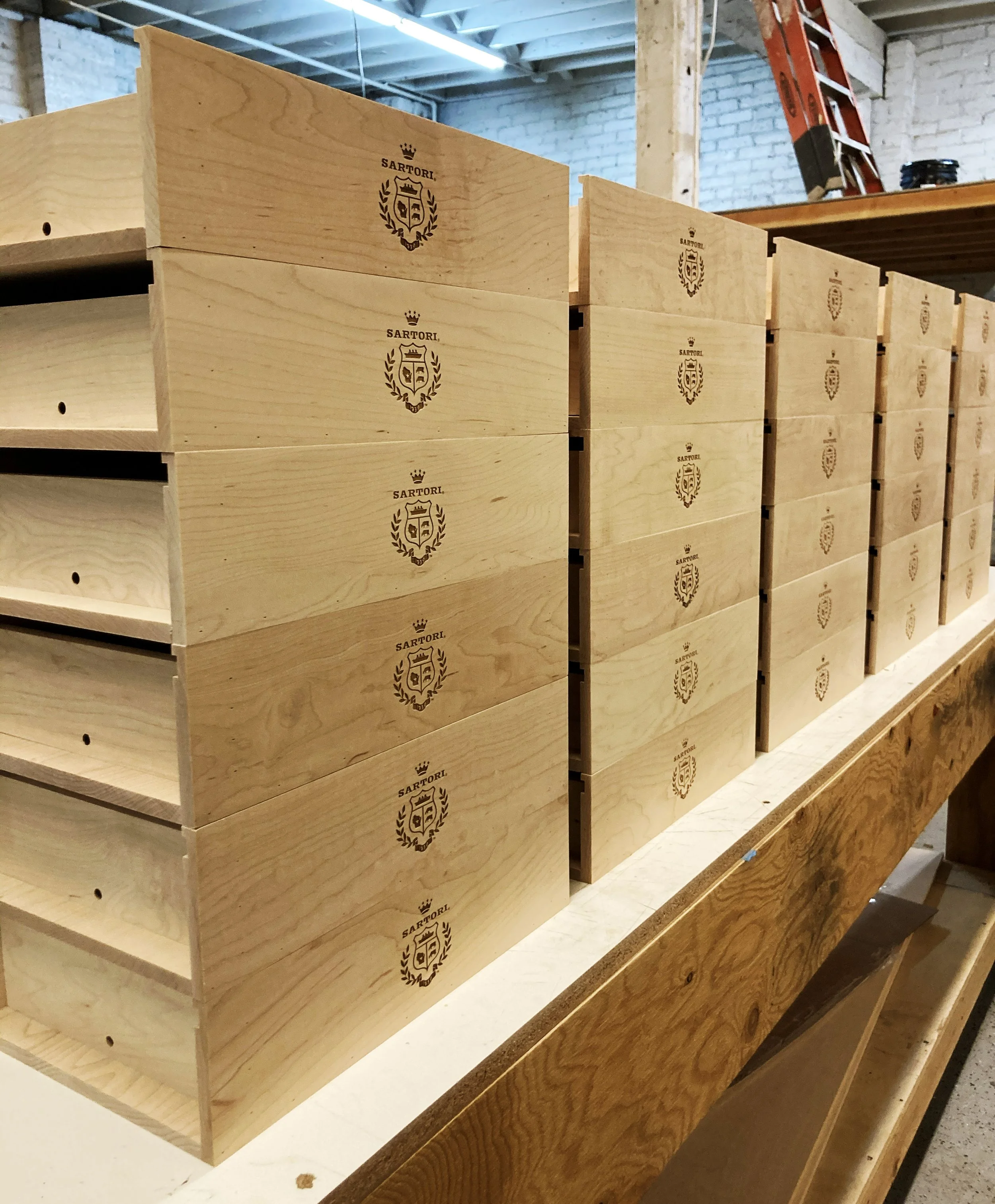 Stack of Sartori Cheese wooden seeding kit boxes with crest logo, custom fabrication by MC Laser Labs.