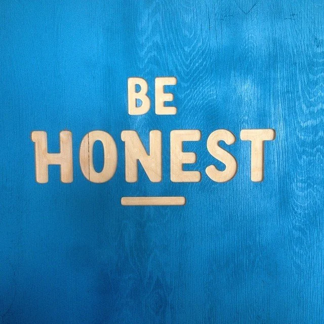 Letter tiles spelling out 'BE HONEST' on a blue background.