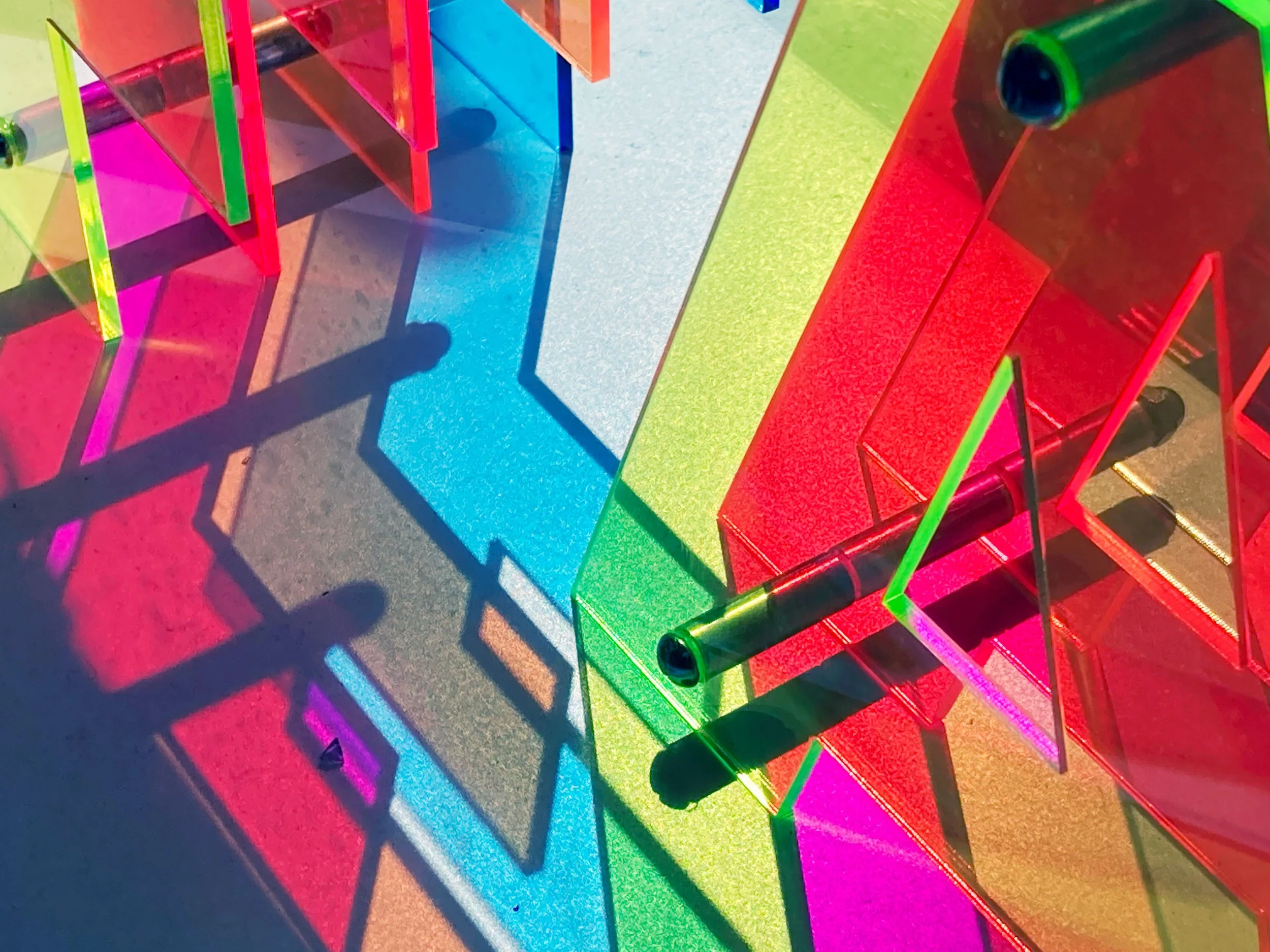Colorful CO2 laser-cut acrylic furniture and decor pieces with layered shadows and light reflections, custom laser cutting by MC Laser Labs.