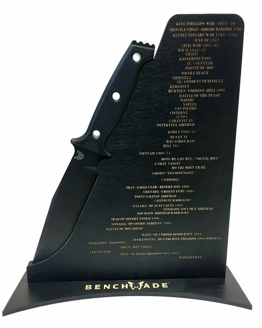 CO2 laser engraved black Benchmade knife-shaped memorial plaque with gold text listing military historical events and the Benchmade logo, custom laser engraving by MC Laser Labs.