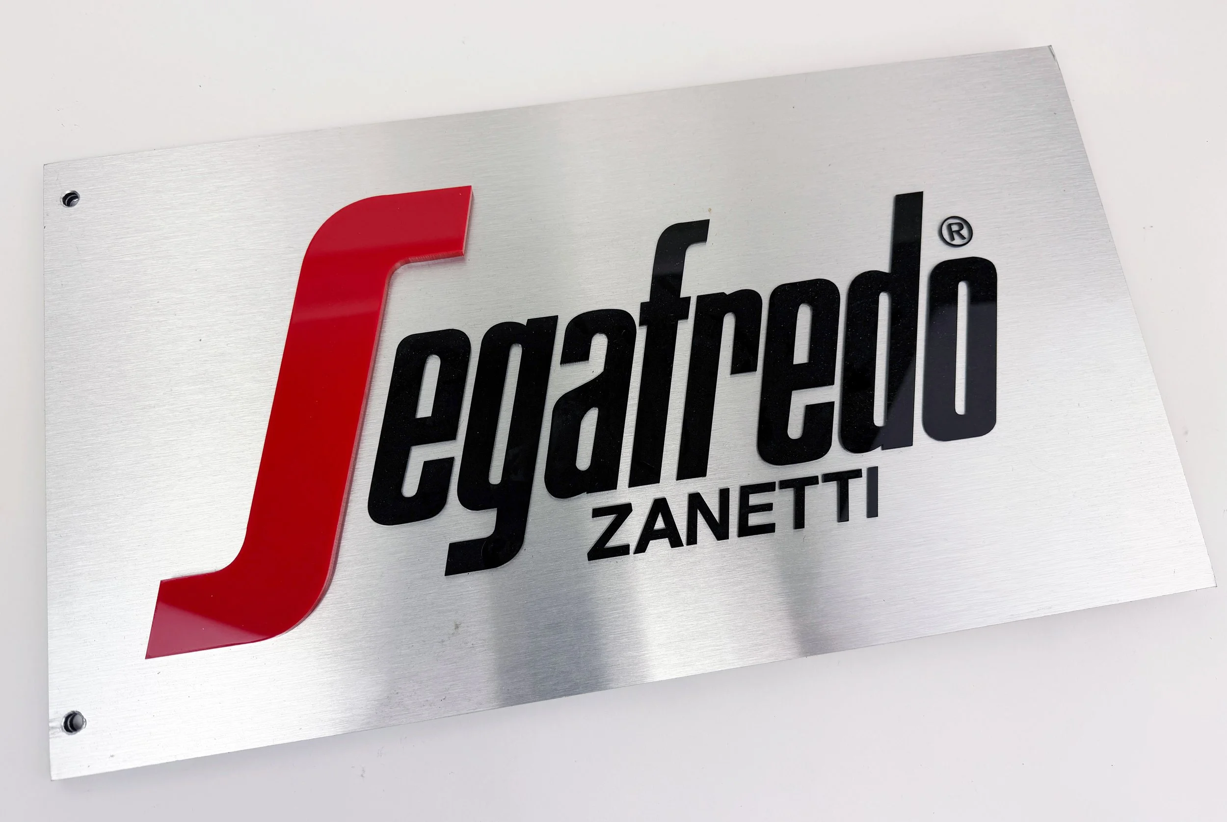 CO2 laser cut and engraved metal sign for Segafredo reading 'Fujifilm ZANET', custom laser cutting and engraving by MC Laser Labs.