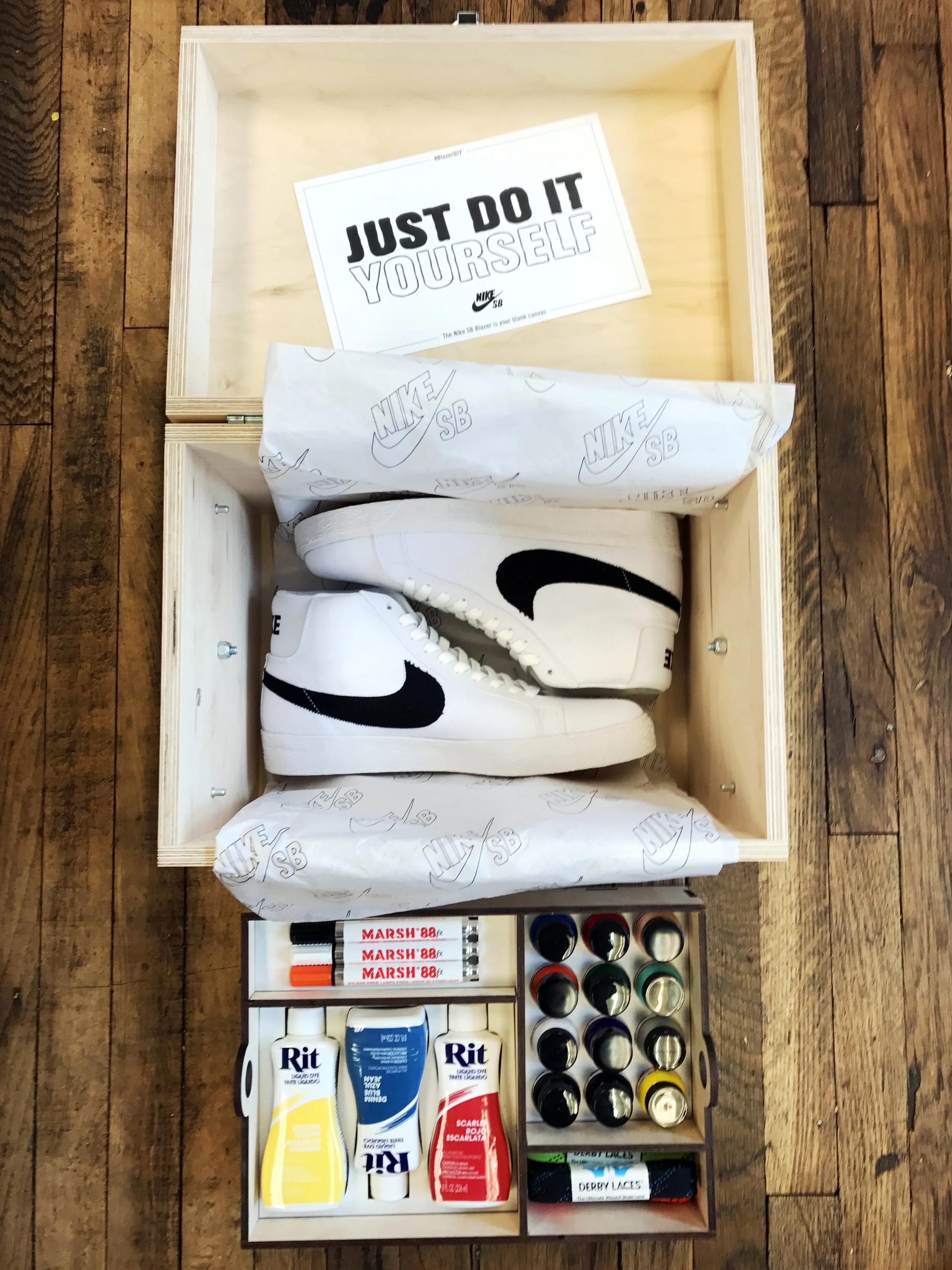 Nike SB 'Just Do It Yourself' wooden seeding kit box with Nike SB shoes, skateboarding supplies, and colored lacquers, custom fabrication by MC Laser Labs.
