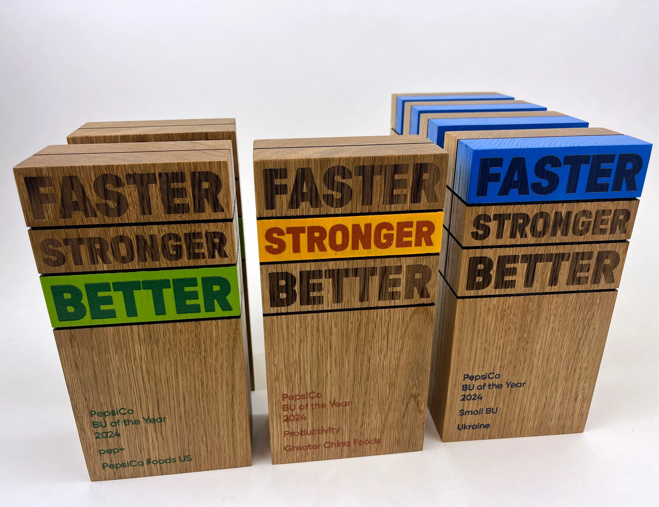 CO2 laser engraved and cut wooden awards for PepsiCo, recognizing BU of the Year 2024 in categories Better, Stronger, and Faster, custom laser engraving by MC Laser Labs.