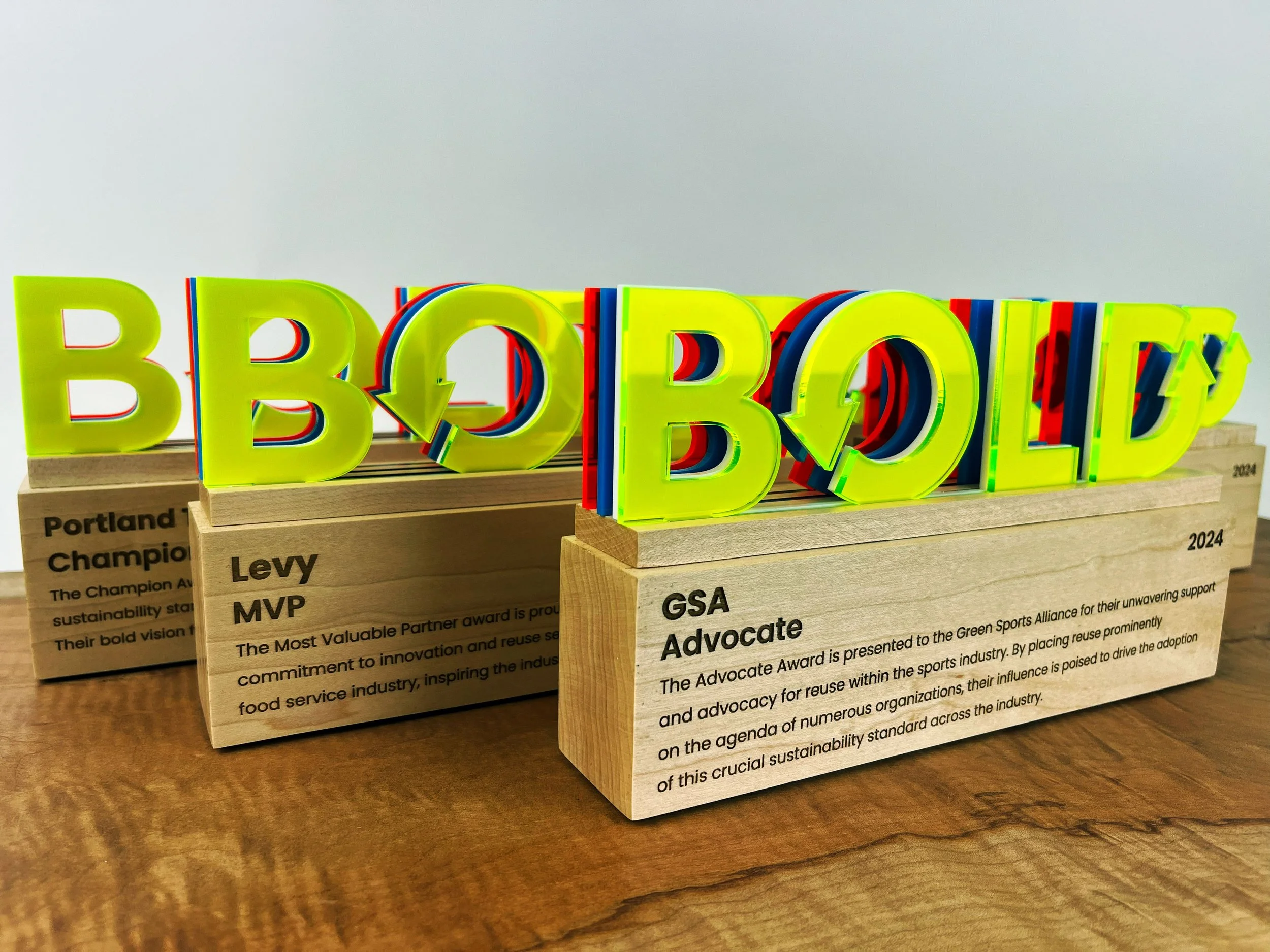 CO2 laser cut neon acrylic and laser engraved maple award reading 'BIBBO', custom laser cutting and engraving by MC Laser Labs.