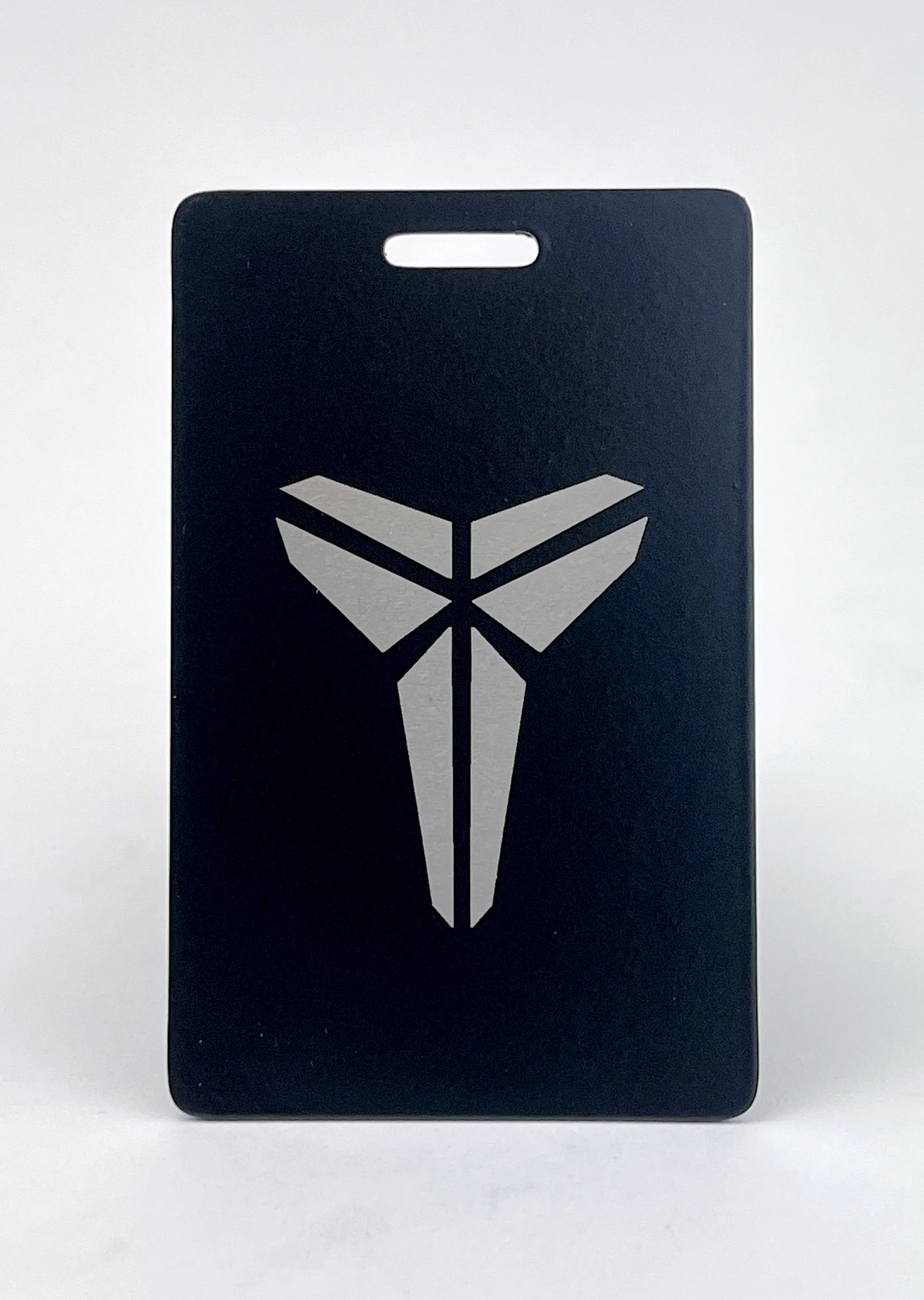 A black card with a white graphic of an animal skull and geometric shapes, placed on a white surface.