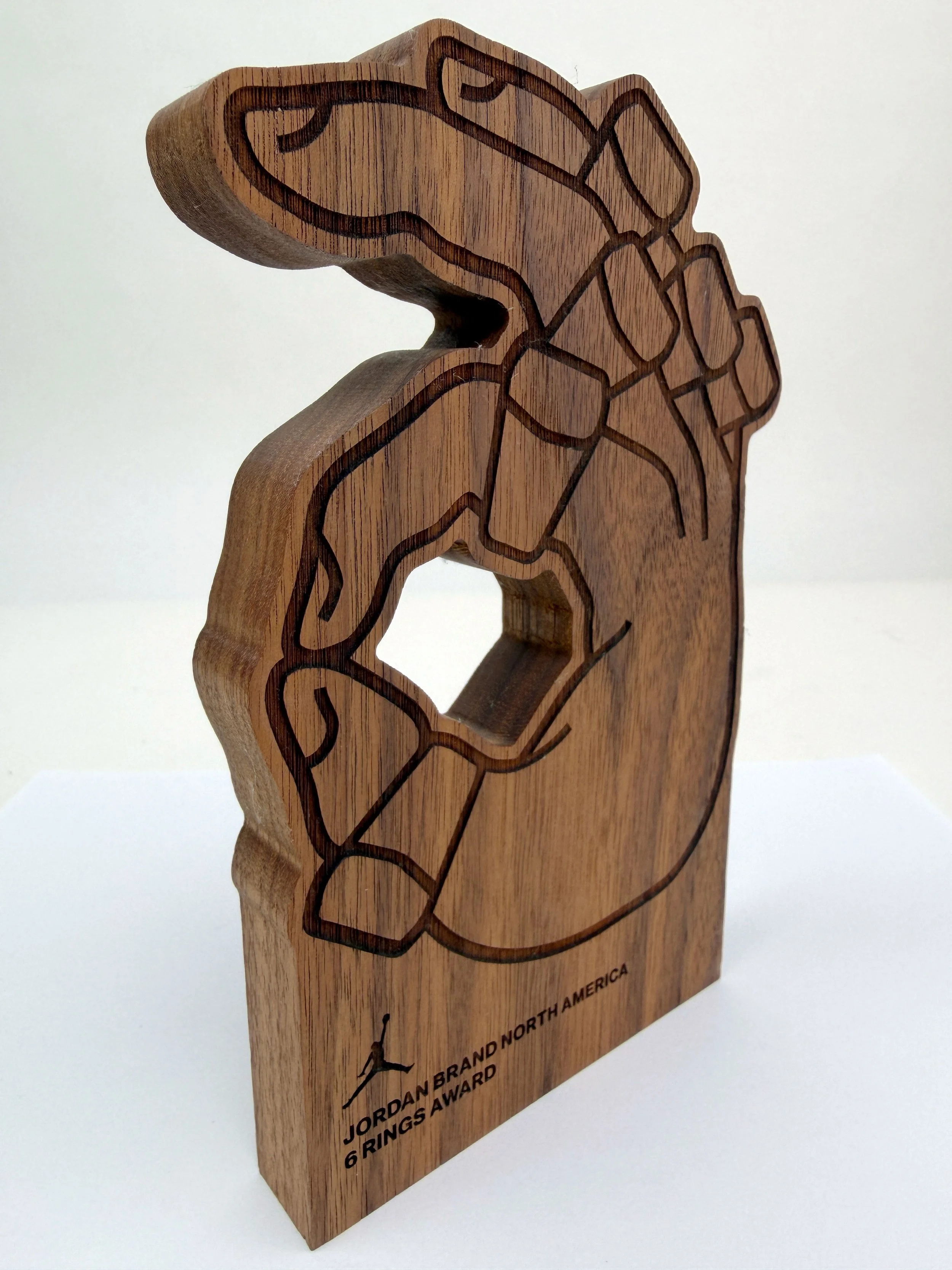 Wooden award plaque in the shape of a hockey mask, engraved with a hockey player silhouette, and text that reads 'Jordan Brand North America 6 Rings Award'.