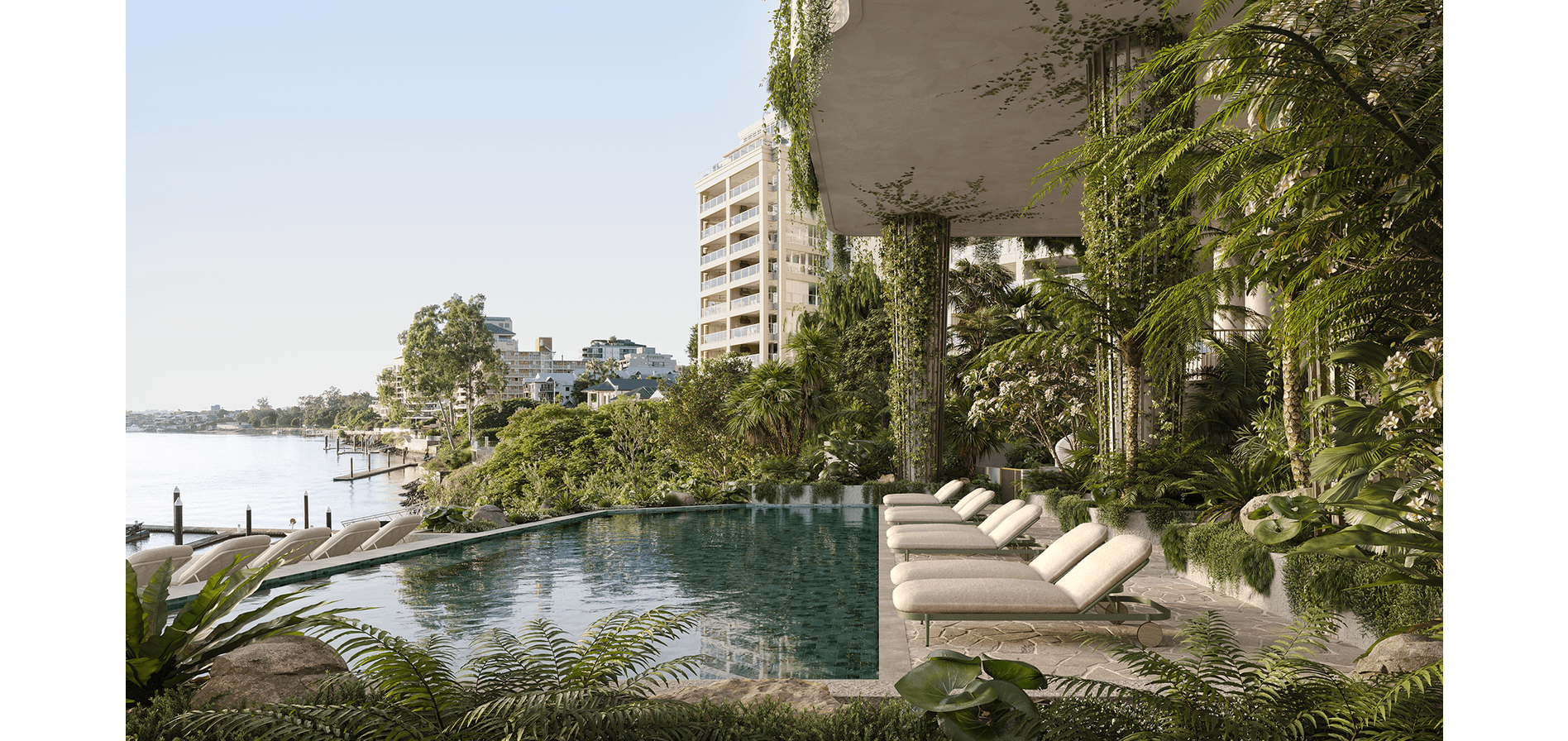 Luxury poolside area with multiple lounge chairs surrounded by lush green plants, overlooking a body of water and modern buildings in the background.