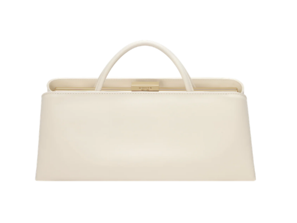 Cream-colored leather handbag with a two interchangable handles and gold-tone hardware, isolated on white background