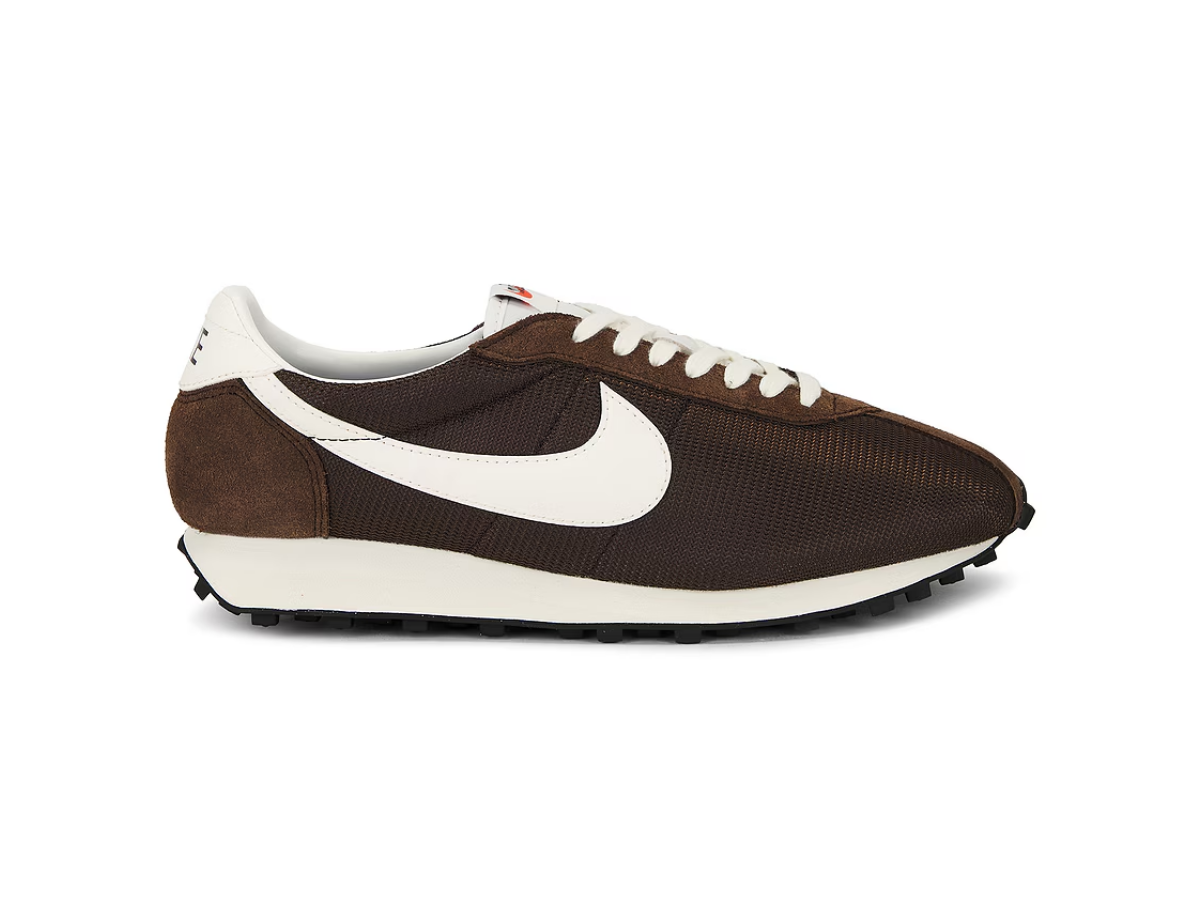 Brown and white Nike running shoe with a mesh upper, white swoosh logo, and black outsole, isolated on a white background.