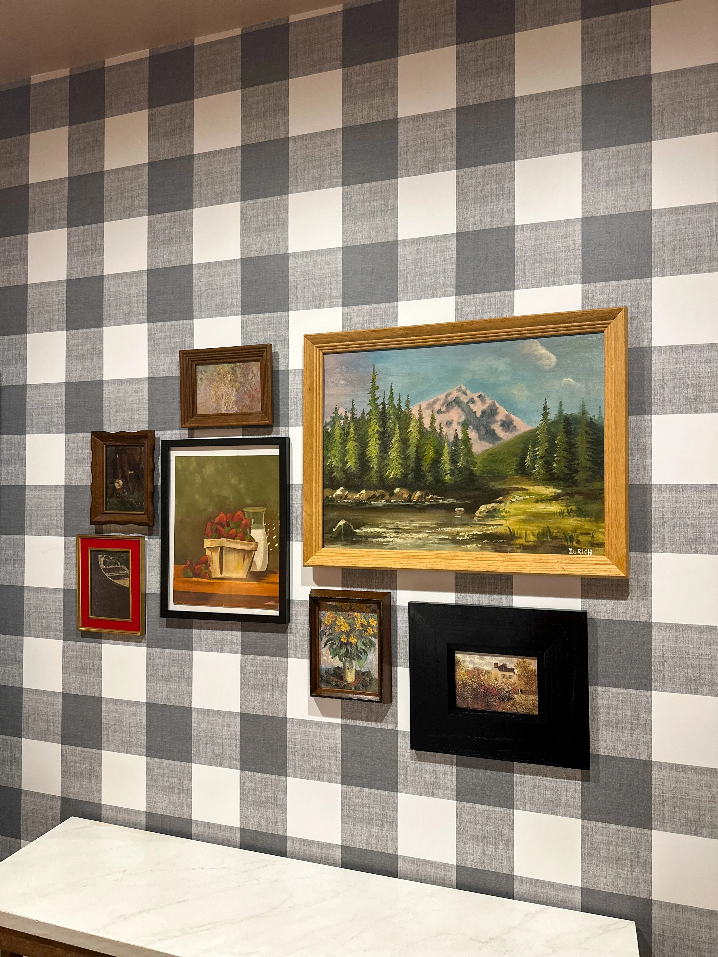 Vintage framed art gallery wall on black and white buffalo check wallpaper