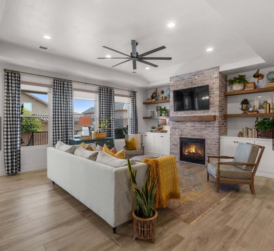 Wide view of living room with white sectional sofa and styled fireplace built-ins