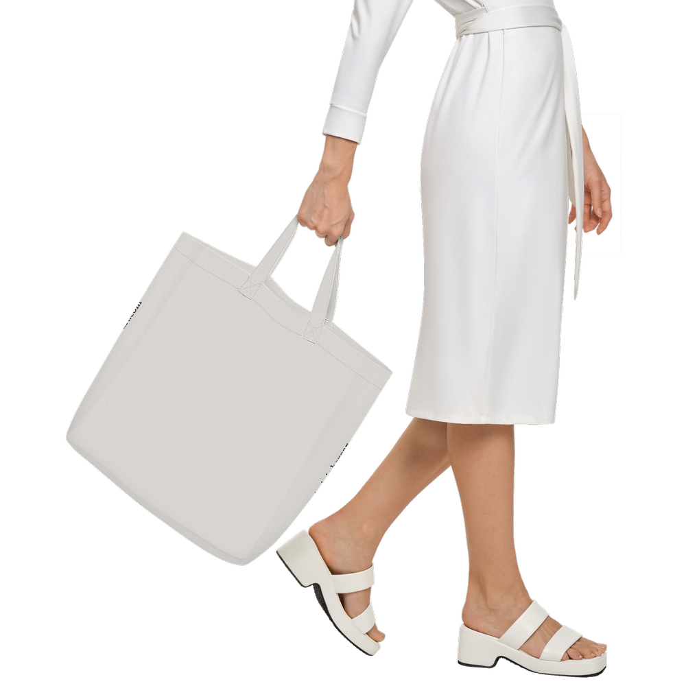 woman walking with a wearble art tote limited edition showing the back of the back which remain free of design.