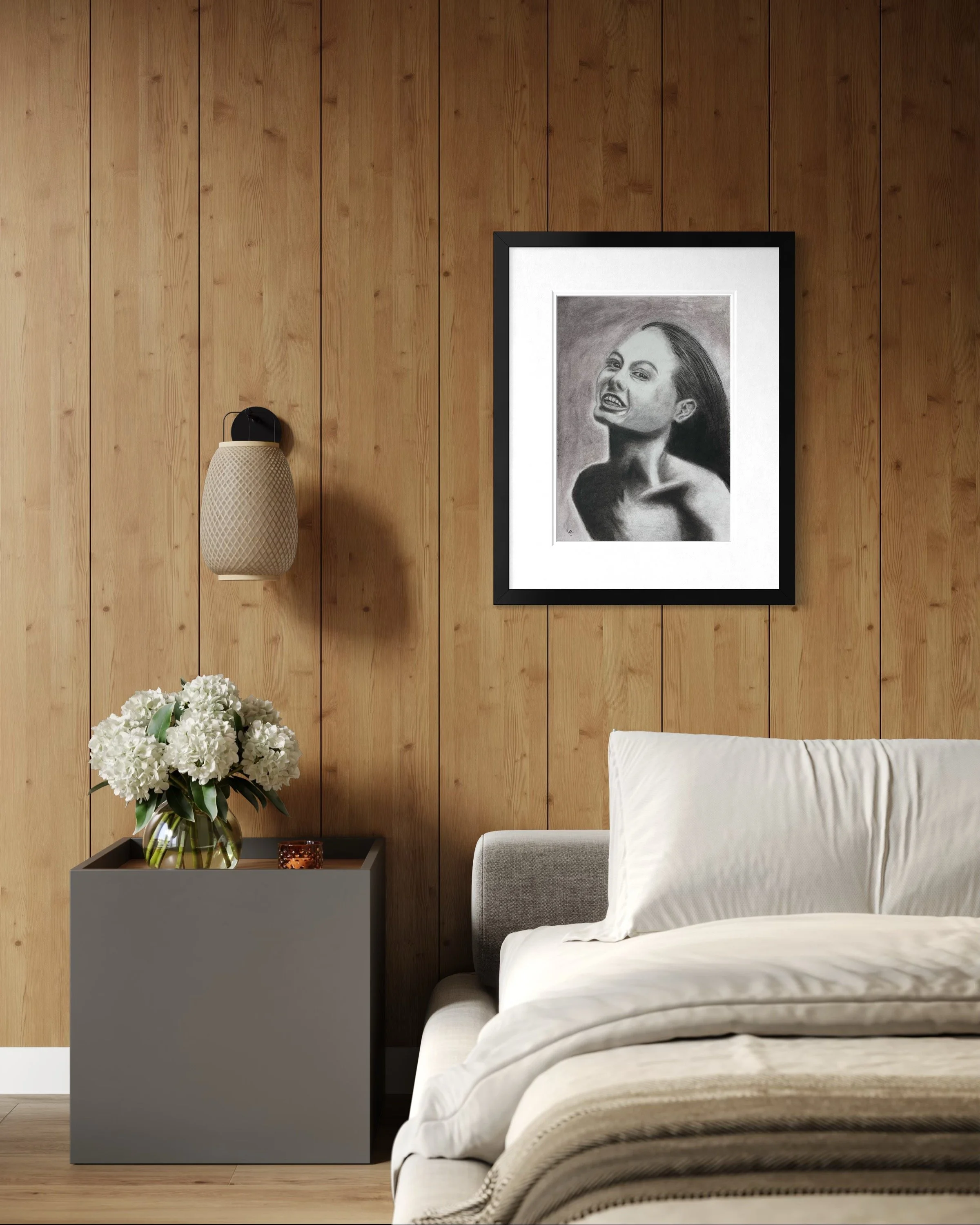 She Laughs Anyway displayed in a black frame above a bed in a warm contemporary bedroom.