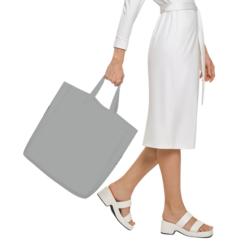 woman walking with a wearble art tote limited edition showing the back of the back which remain free of design