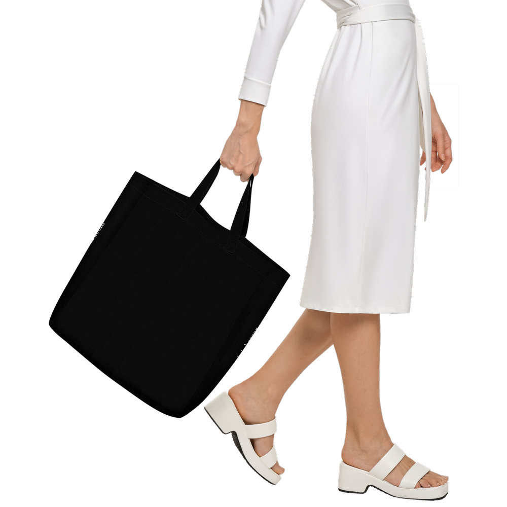 woman walking with a wearble art tote limited edition showing the back of the back which remain free of design