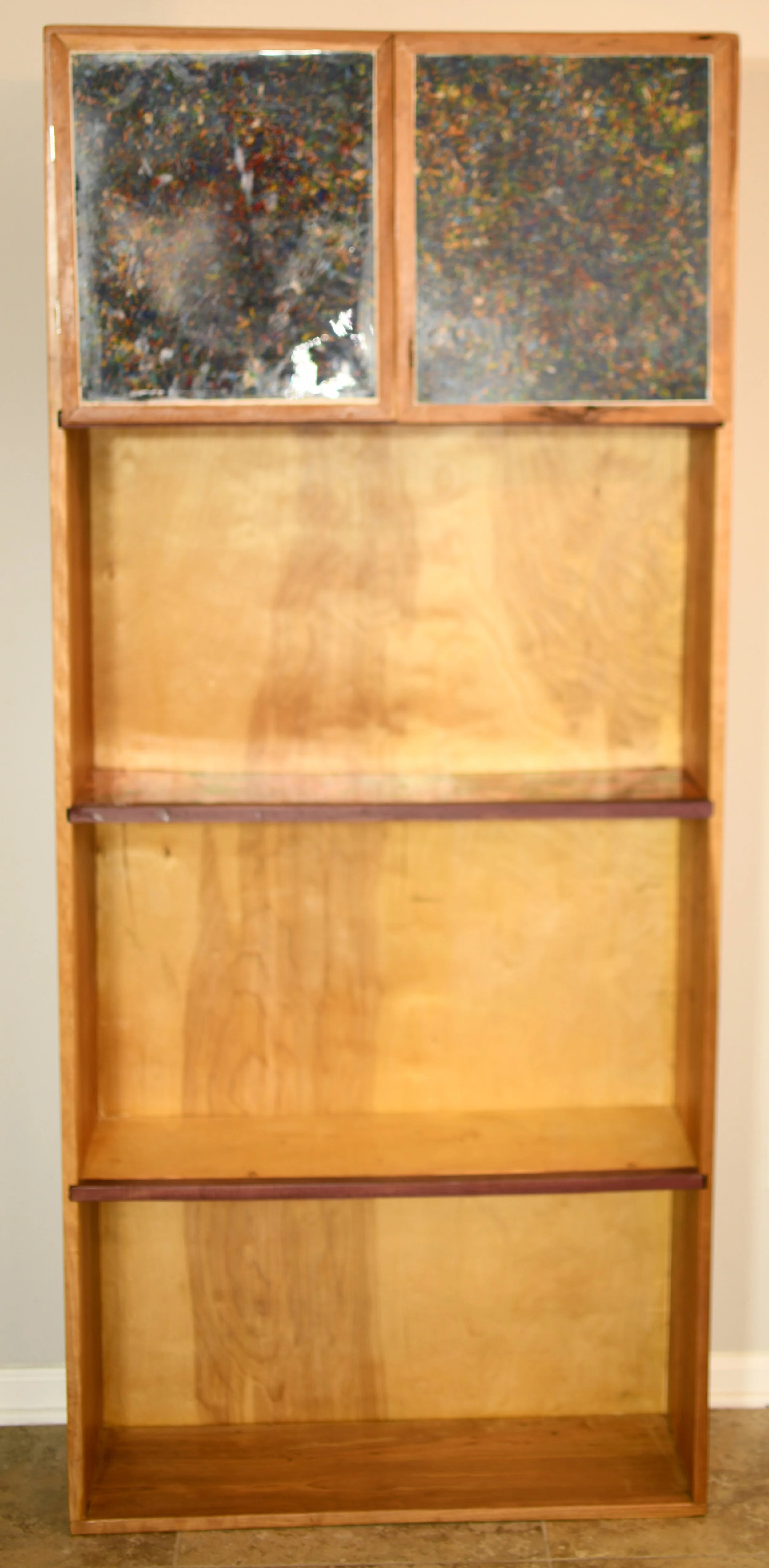 Solid cherry bookshelf with doors. Shredded crayon infused door panels. Second shelf made with a melted crayons covered in resin. Purpleheart wood accents. 