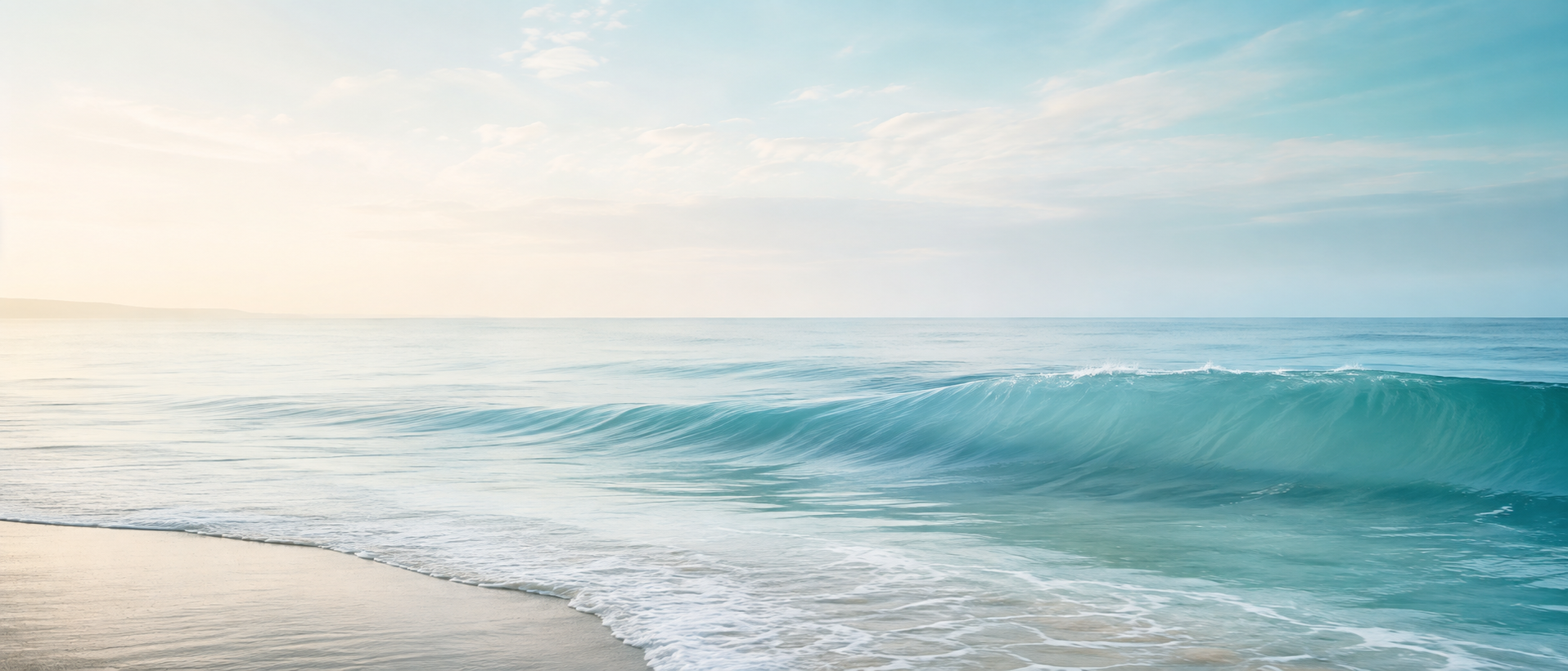 A peaceful ocean scene with gentle waves approaching a sandy beach under a partly cloudy sky.