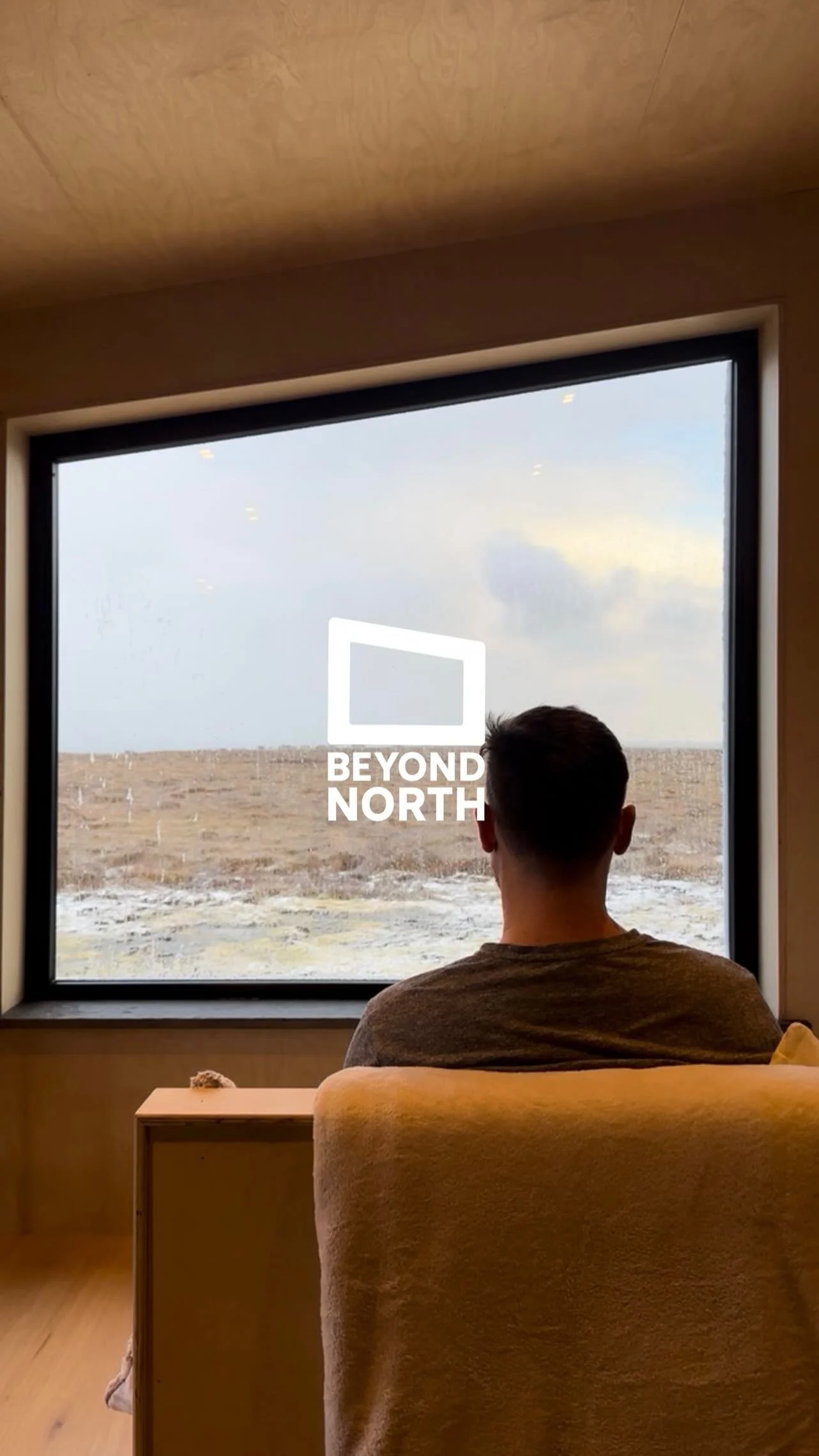 Traveller looking across a winter landscape from a window.