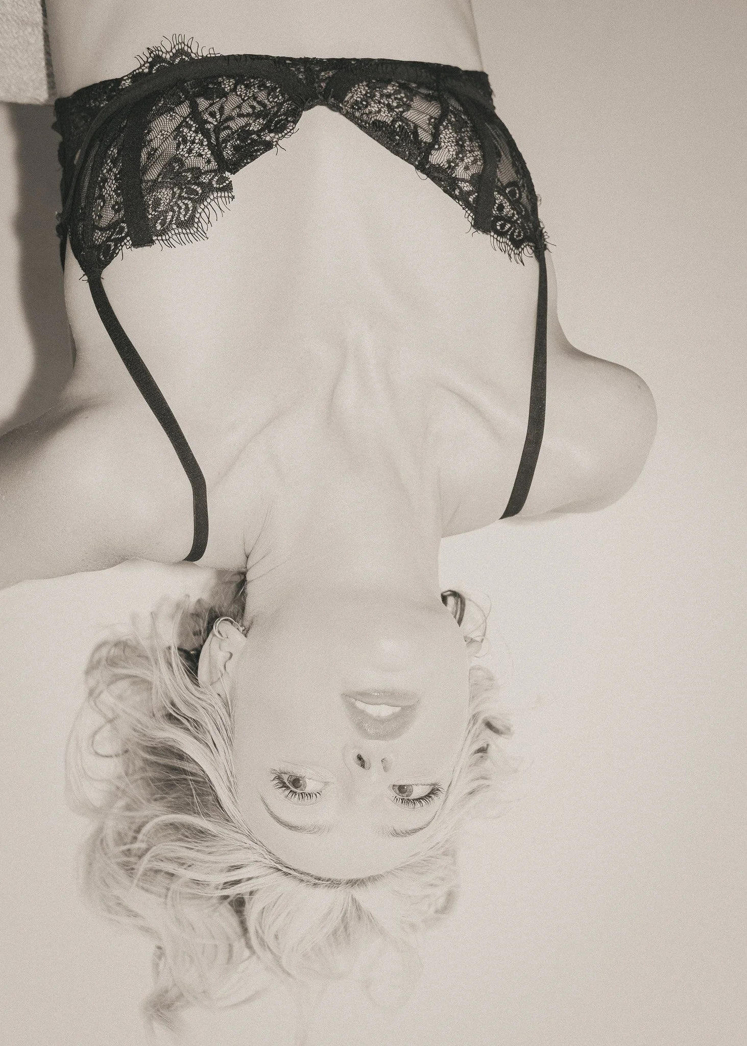 Black lace lingerie headband on a mannequin head with blonde hair, upside down.