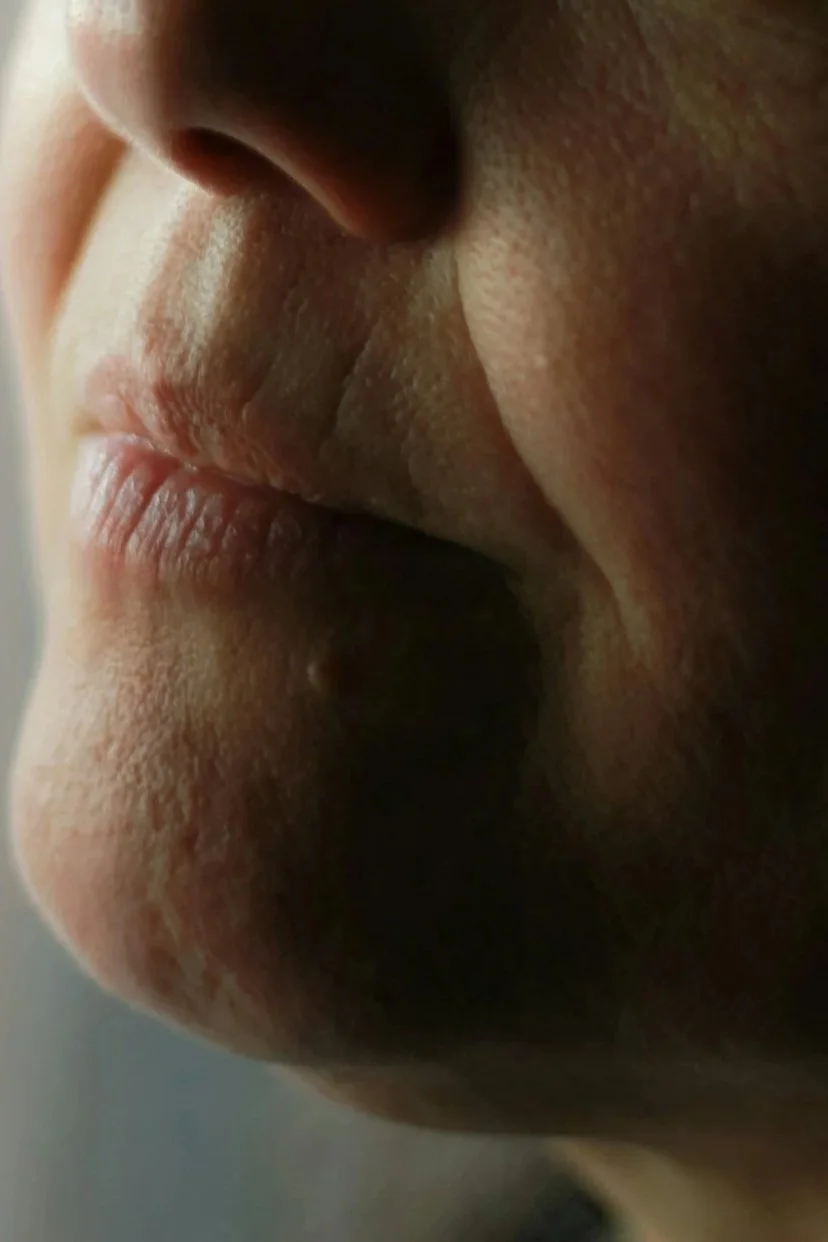 A close-up of a person's nose and mouth, with their lips slightly parted.