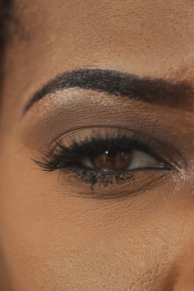 Close-up of a person's eye with makeup, including eyebrow, eyeliner, and eyeshadow.