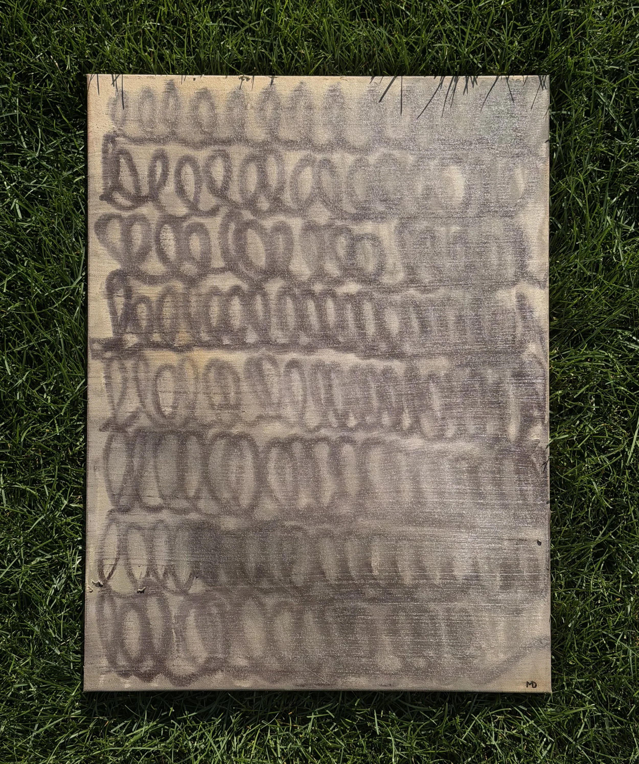 Abstract artwork on canvas with overlapping spiral and oval patterns in shades of gray and brown, placed on green grass
