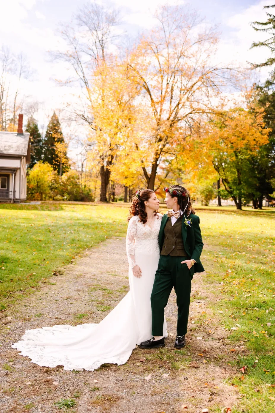 Laurie’s customers, Mariana and Carmen holding hands on a green lawn on their wedding day.