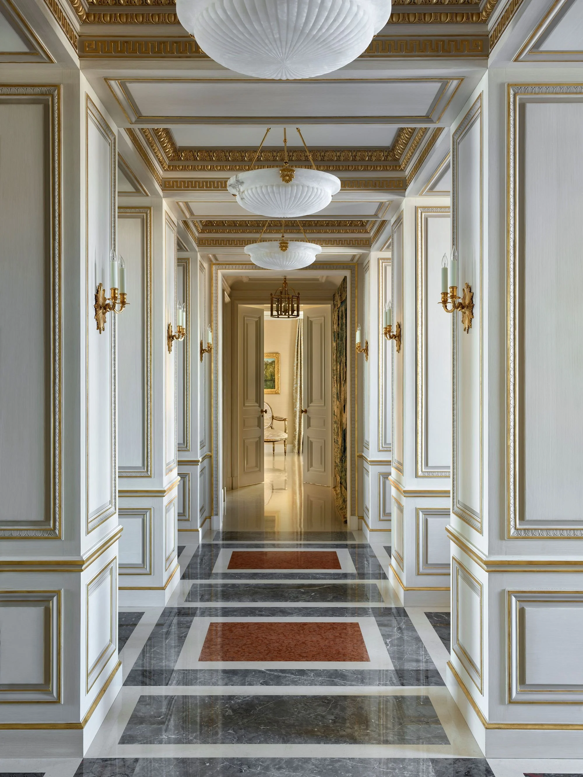 Paneled gallery hall with gilt moldings and inlaid marble floor