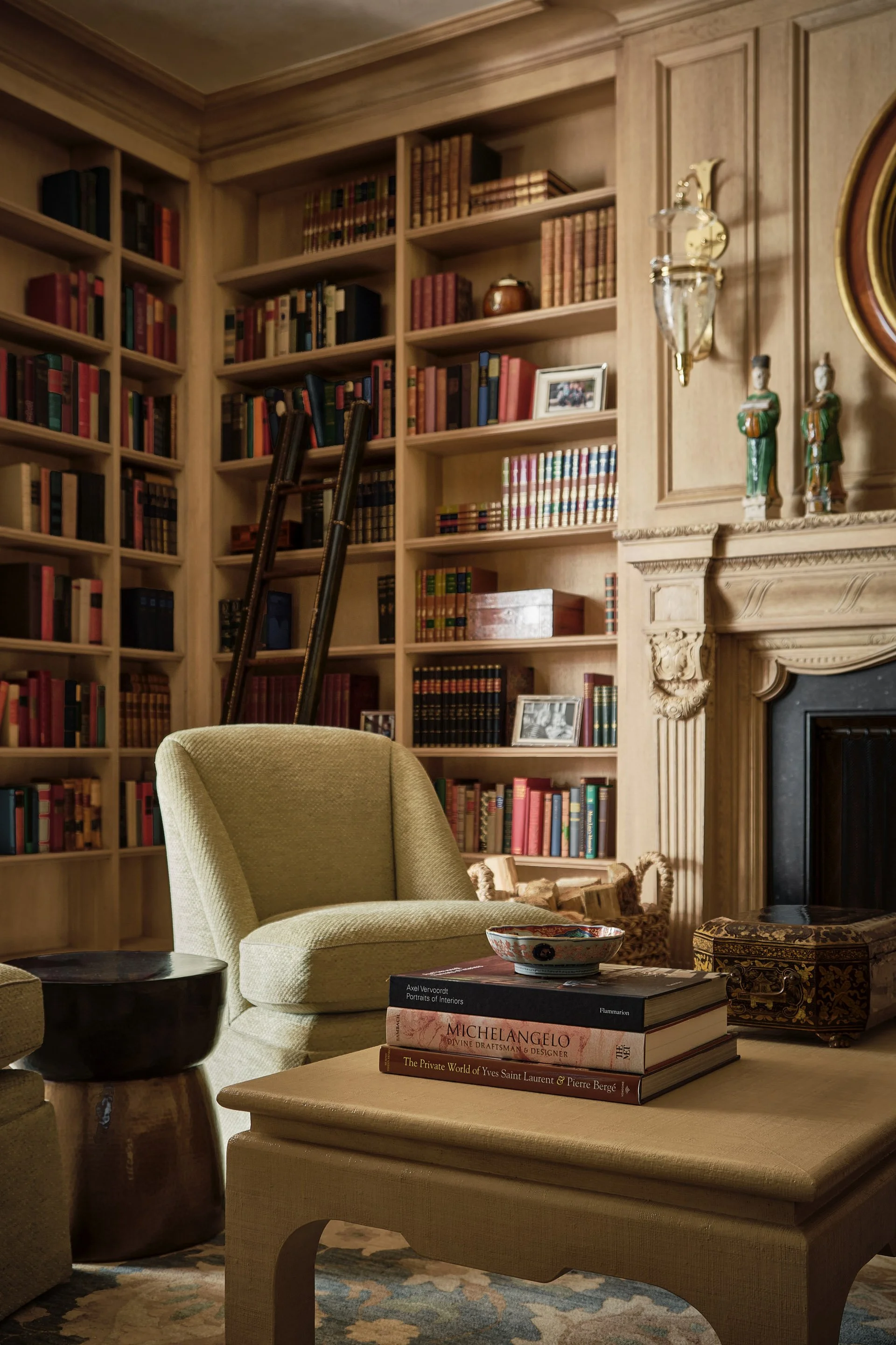 1. Library with floor-to-ceiling bookshelves, rolling ladder, and pale green armchair by the fireplace, Hillsborough Estate