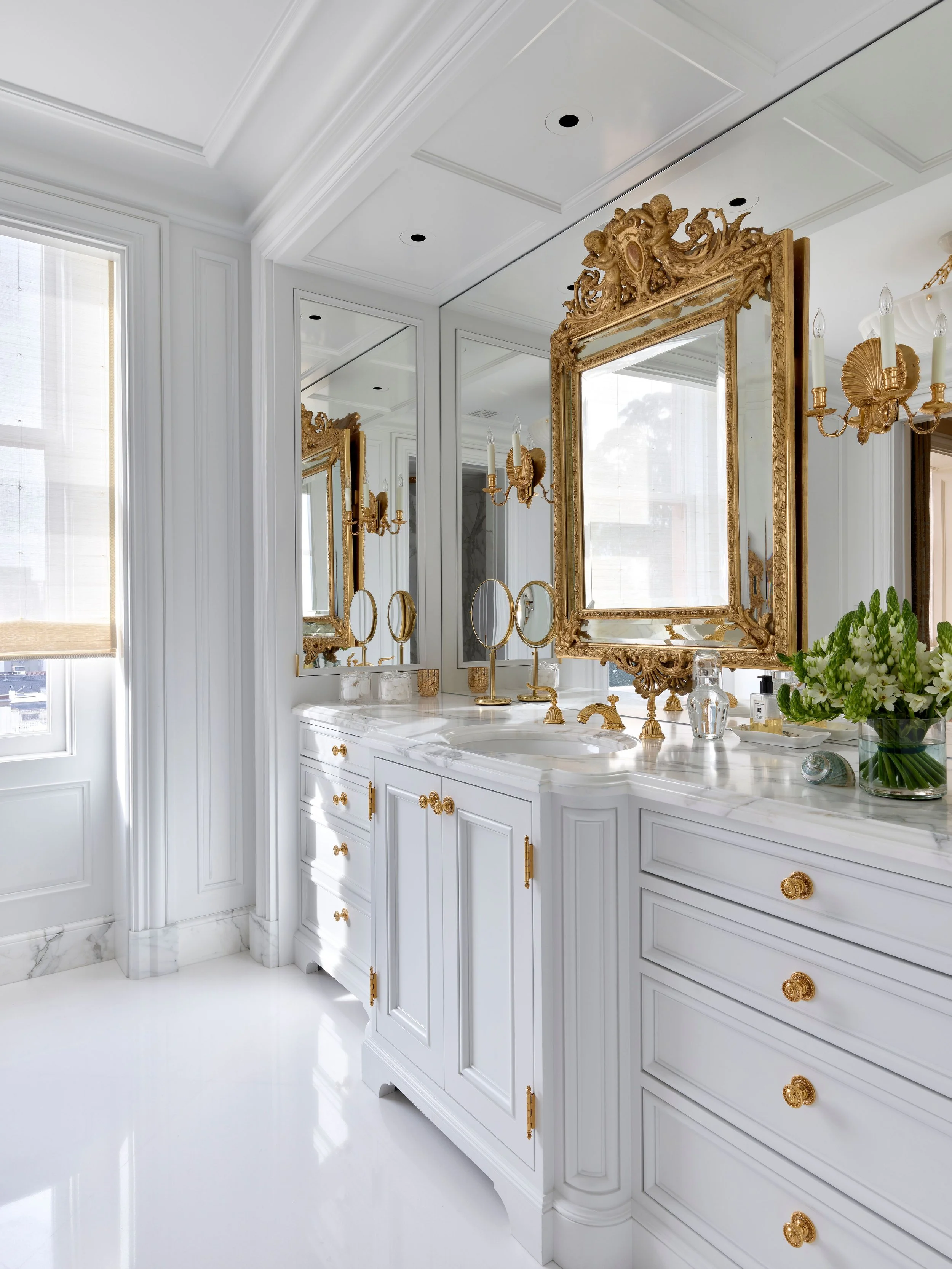 Mirrored bathroom with gilt mirror, white vanity, and brass fittings, Classic French Apartment