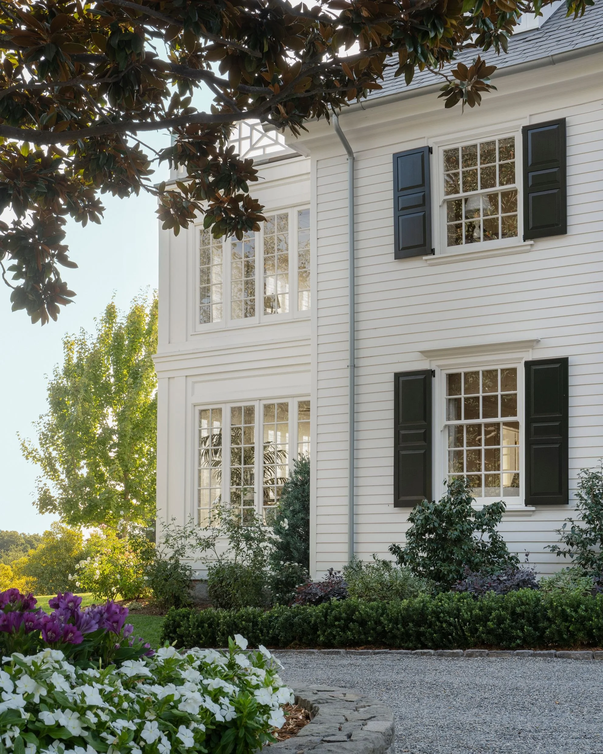 White clapboard Georgian exterior with black shutters and mature gardens